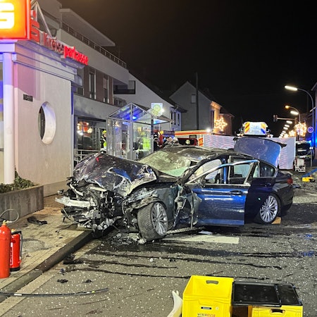 Ein komplett zerstörtes Auto steht nach einem Unfall auf der Straße.