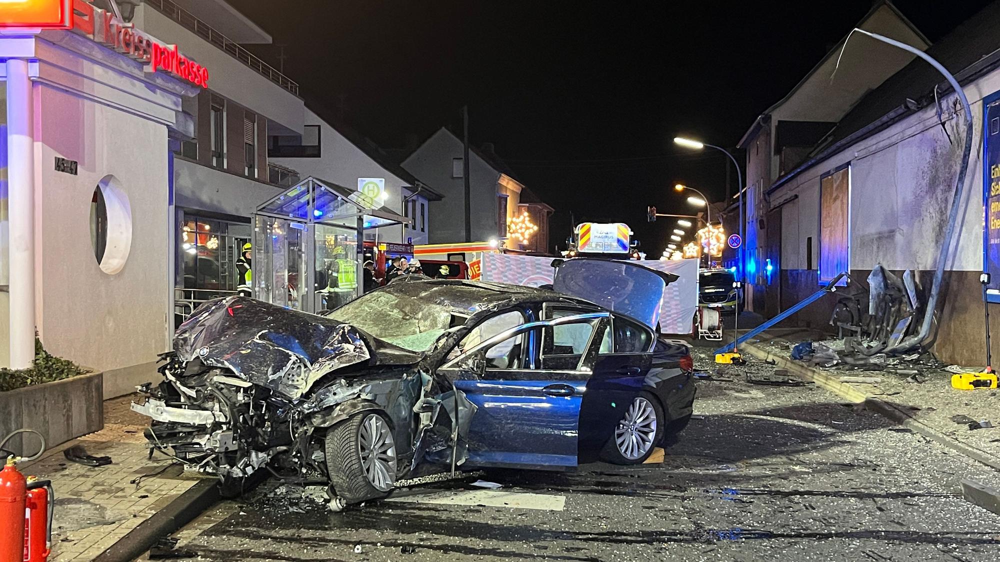 Ein komplett zerstörtes Auto steht nach einem Unfall auf der Straße.