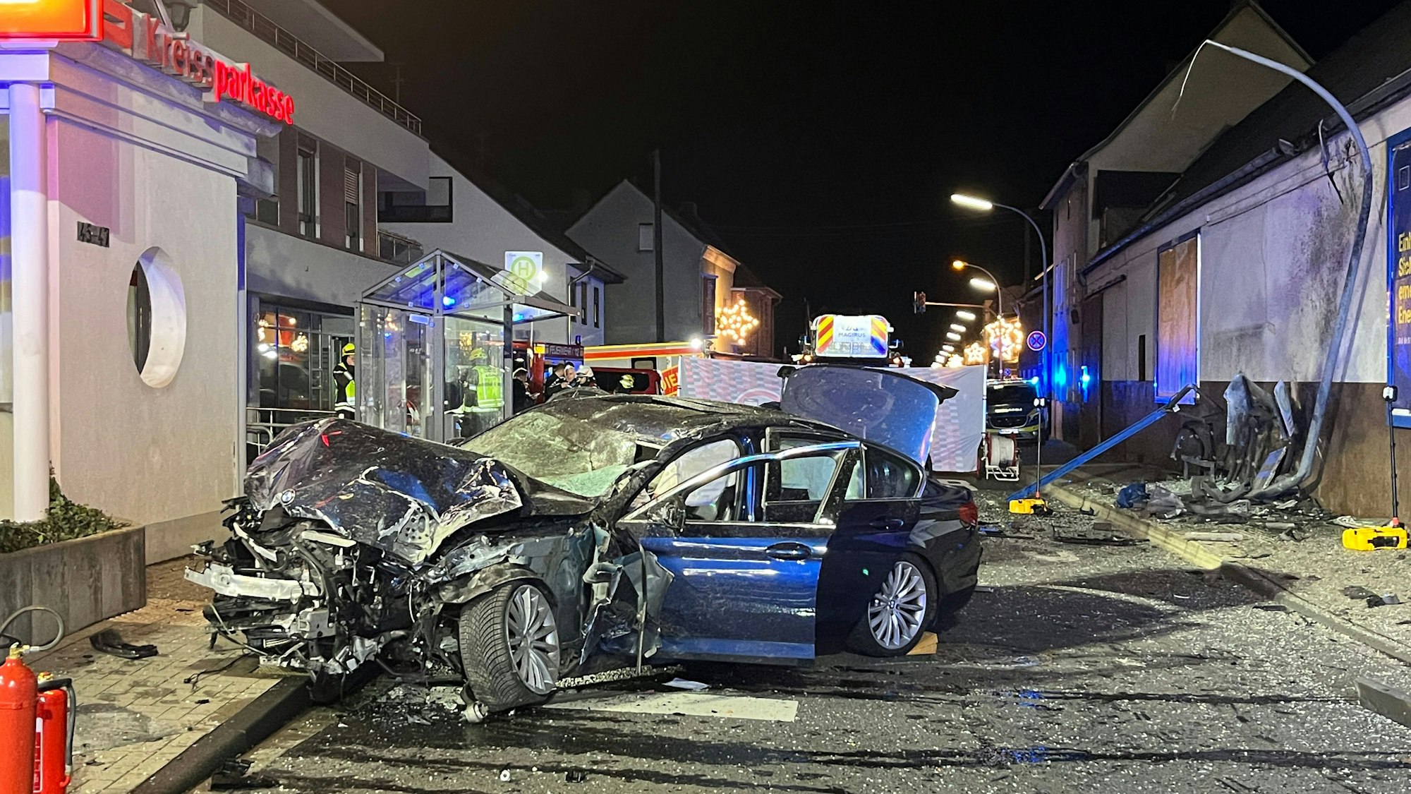 Ein komplett zerstörtes Auto steht nach einem Unfall auf der Straße.