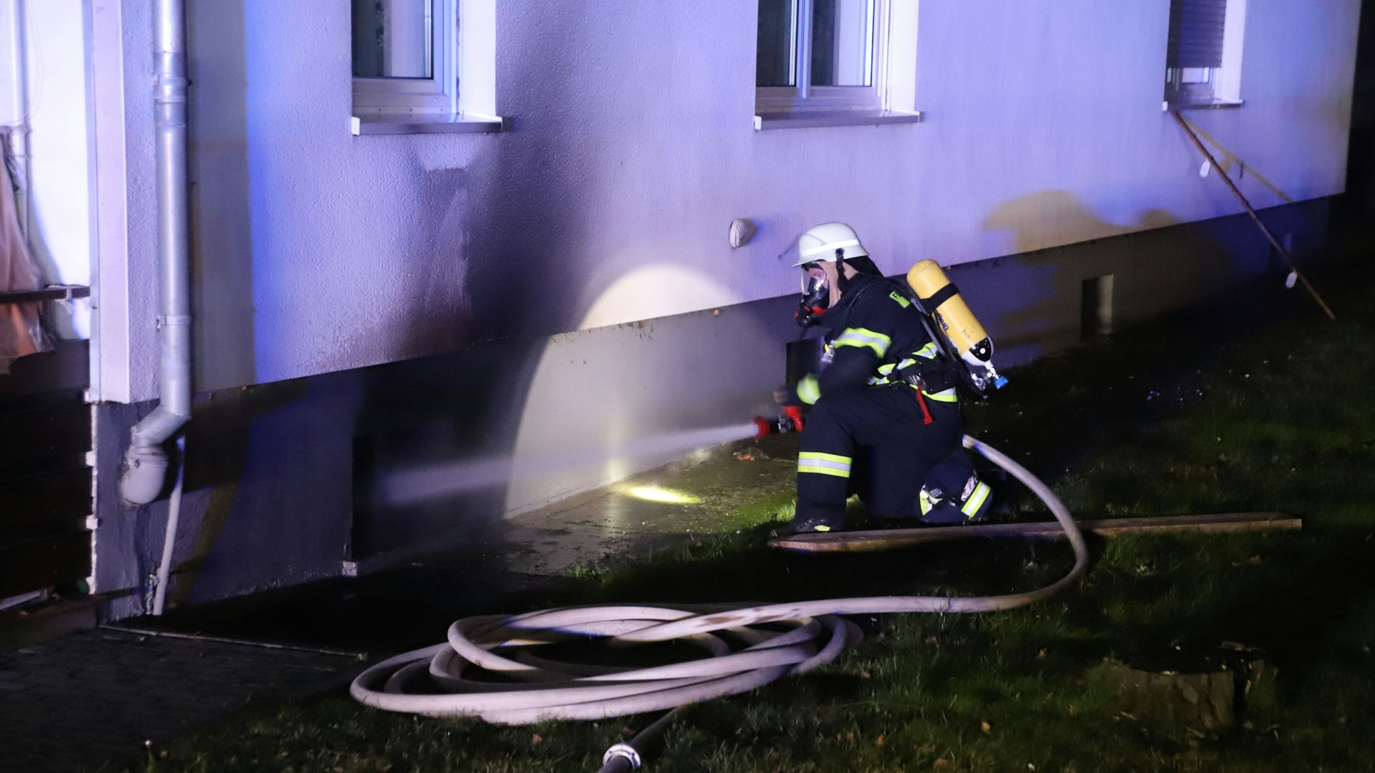 In einem Mehrfamilienhaus an der Heidestraße in Stoßdorf brannte es im Keller. Wehrleute unter Atemschutz löschten auch von außen.