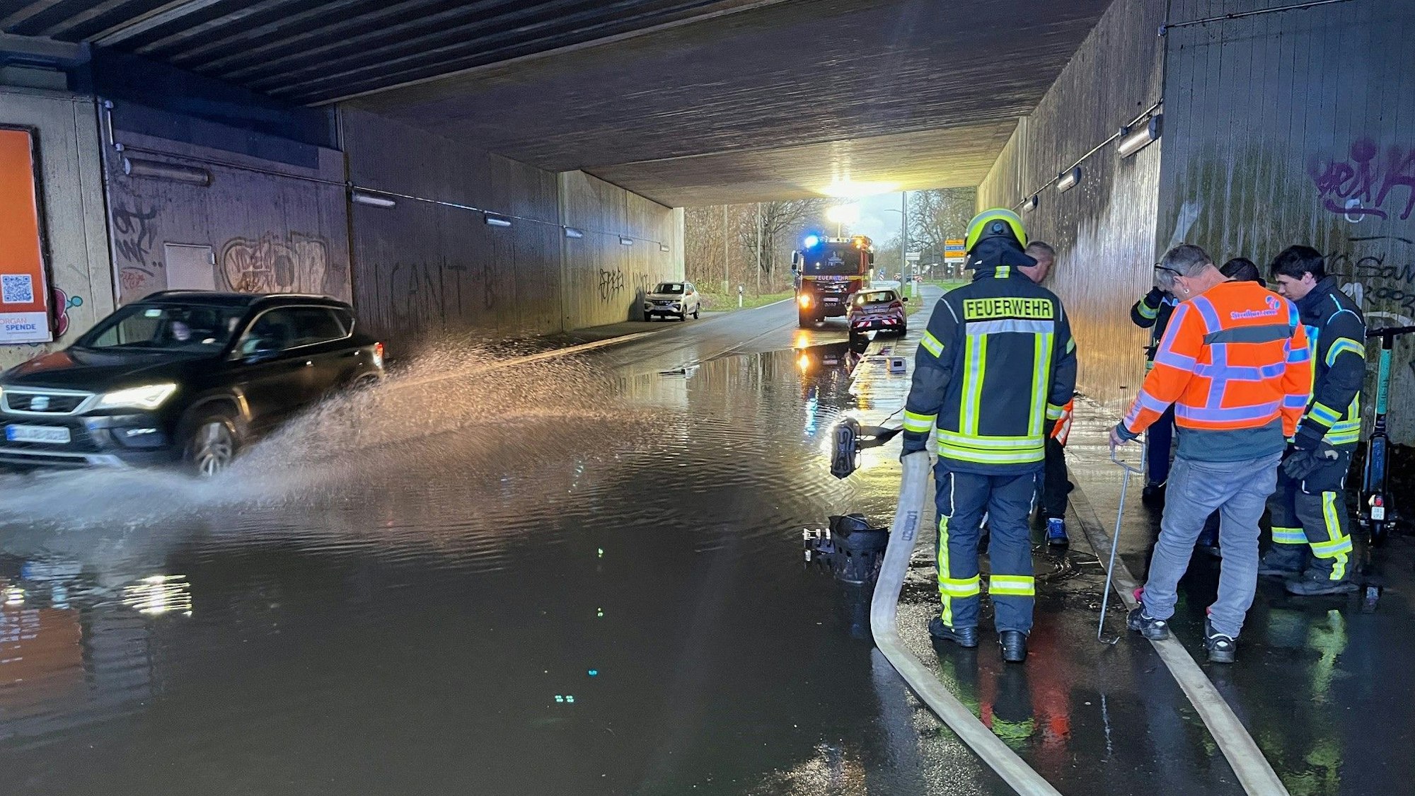 Feuerwehrleute im Einsatz an einer gefluteten Unterführung.
