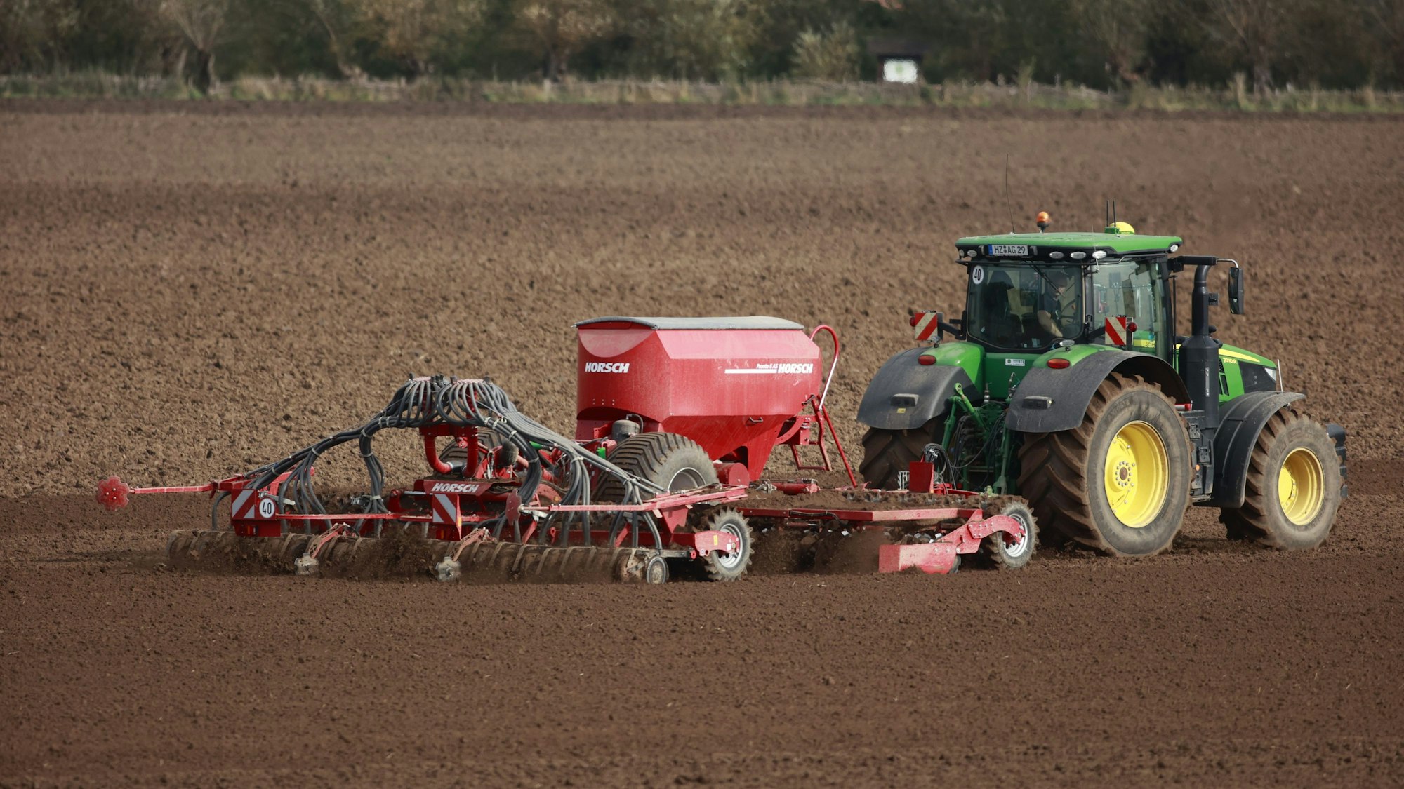 Ein Landwirt sät ein Feld frisch ein.