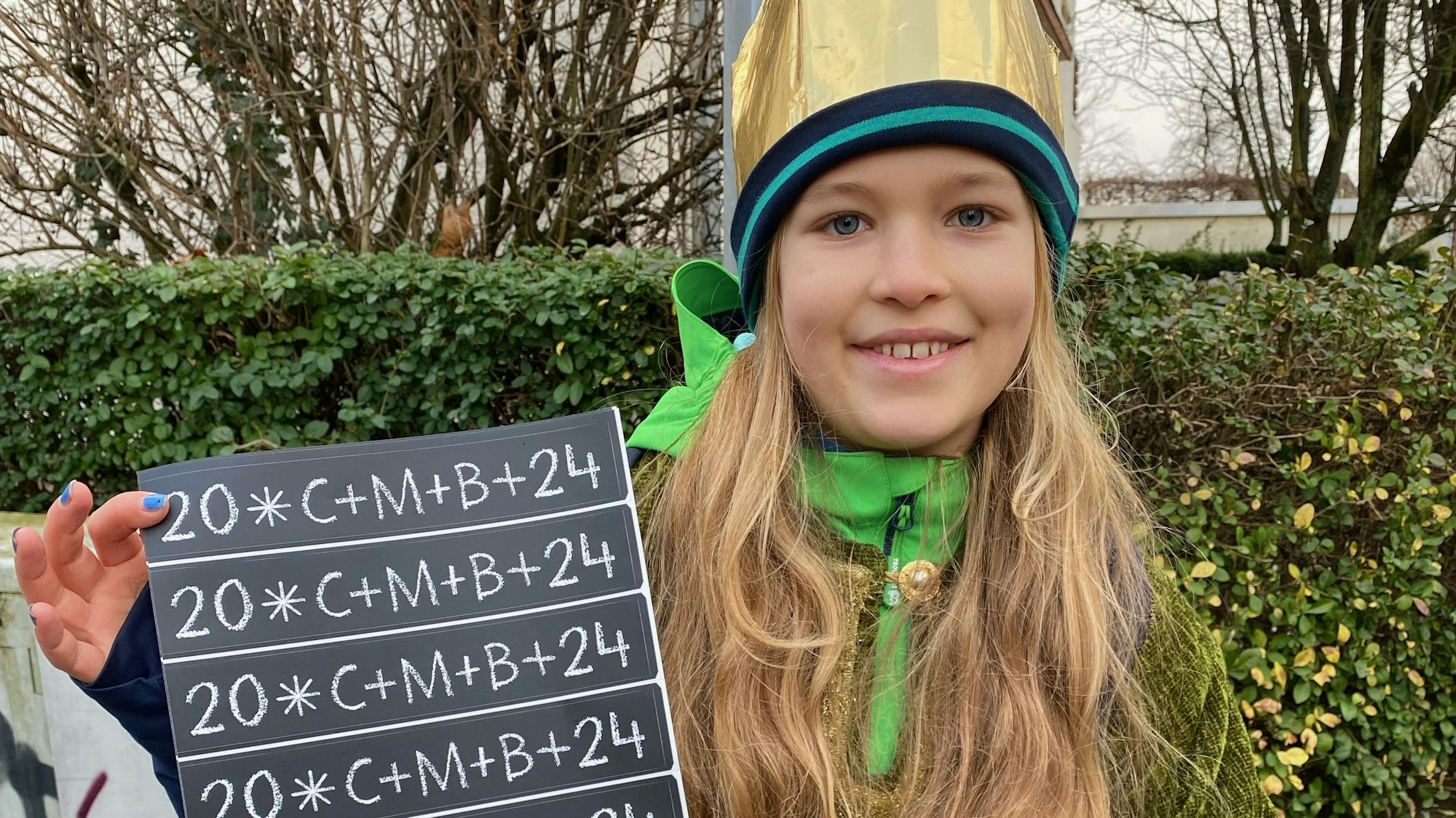 Sternsinger Hanna zeigt den Klebesegen.