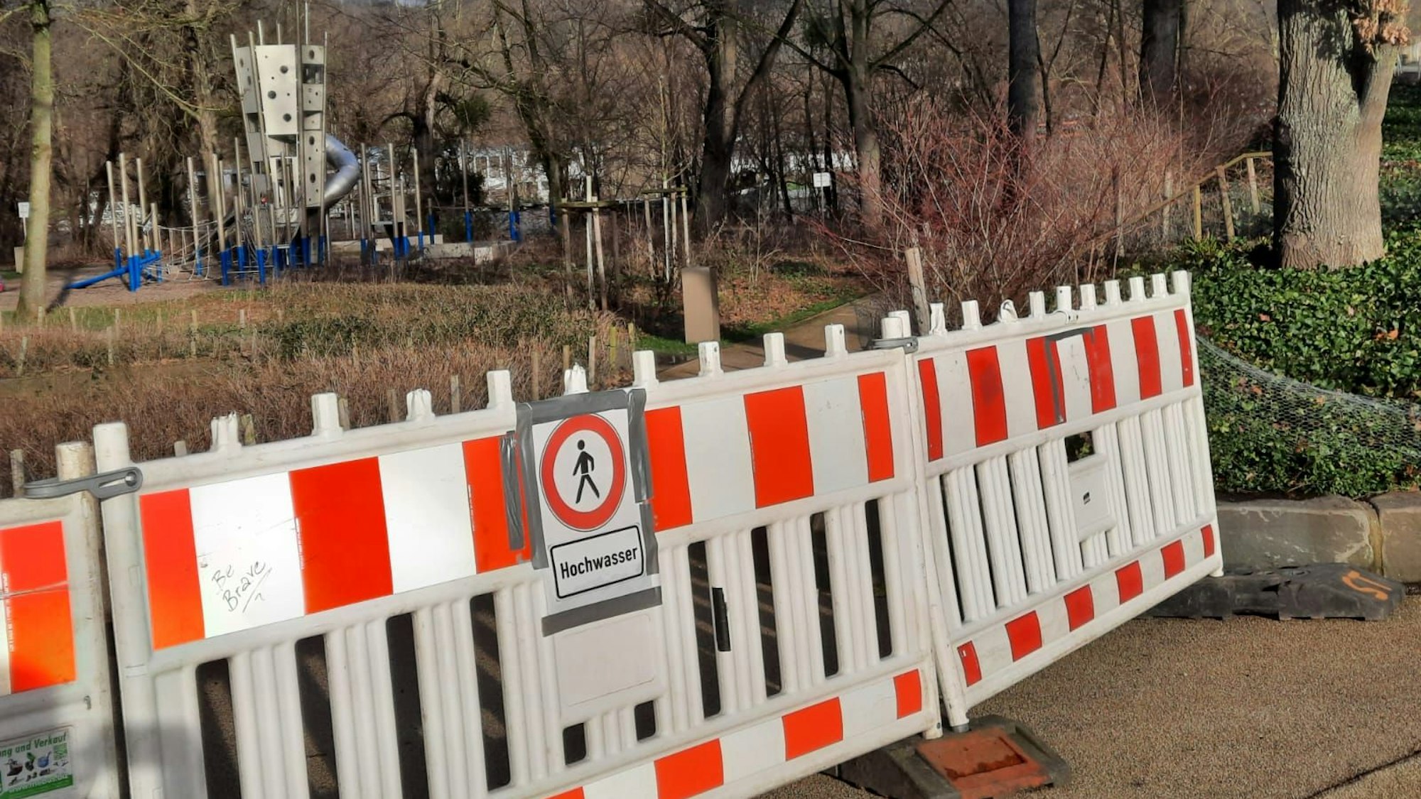 Rot-Weiße Absperrungen mit dem Schild „Hochwasser“ und "Durchgang verboten" versperren den Zugang zur Nordspitze der Insel Grafenwerth.