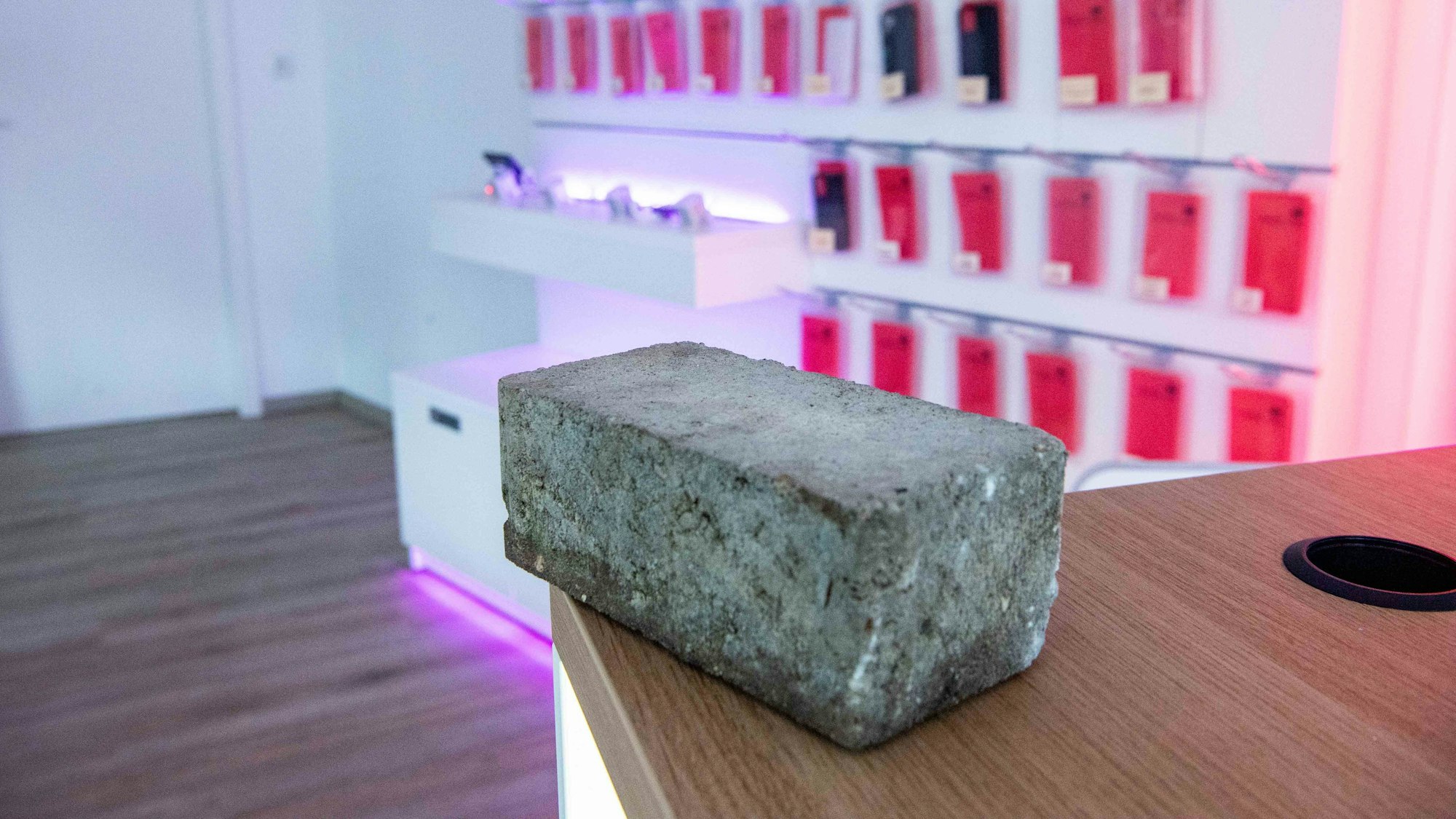 Das Bild zeigt einen Pflasterstein. Er liegt auf einem Tresen im Handyladen.