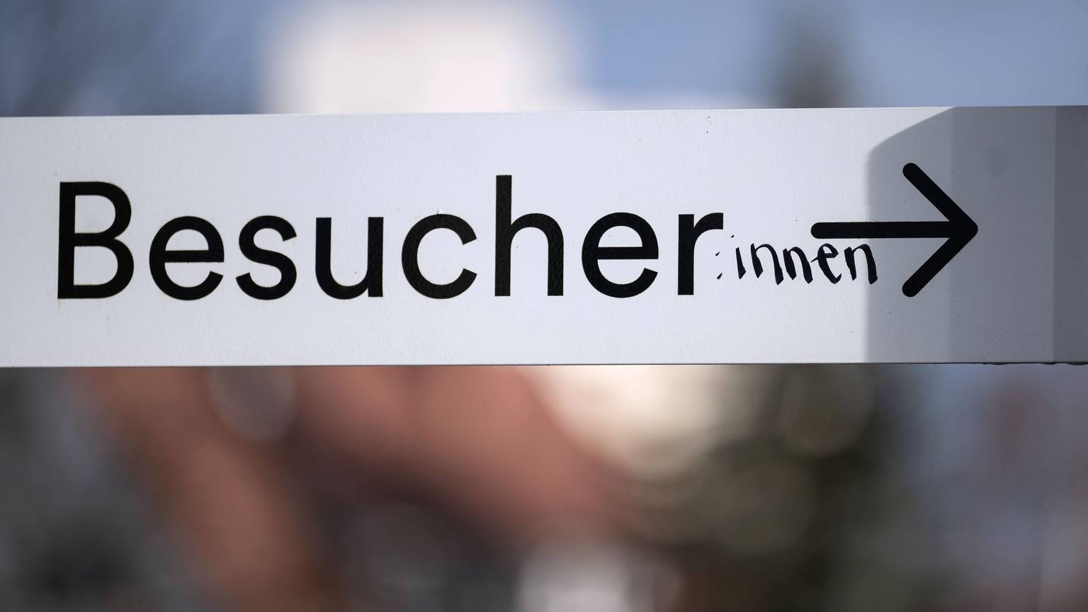 Das Wort „Besucher“ ist auf einem Schild in der Innenstadt mit dem Zusatz „:innen“ versehen.