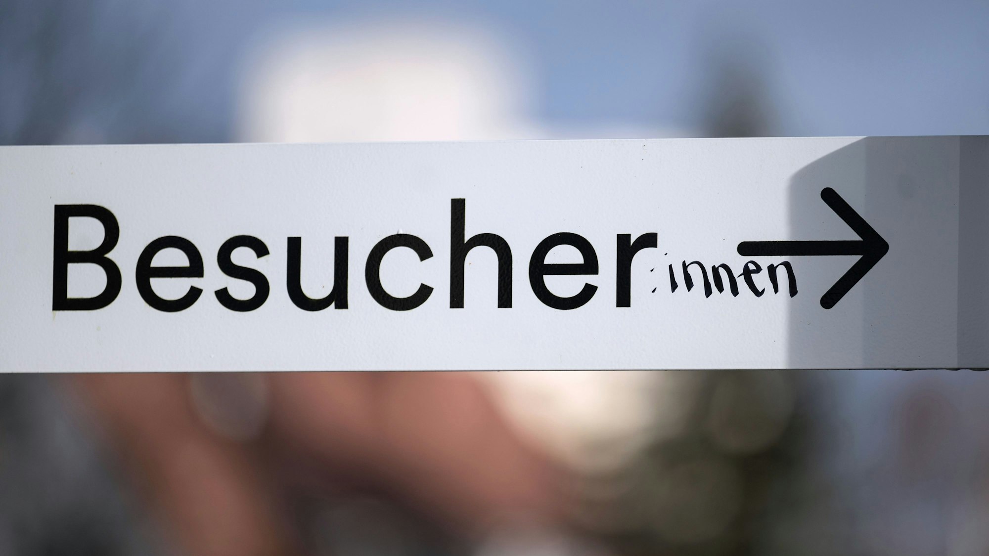 Das Wort „Besucher“ ist auf einem Schild in der Innenstadt mit dem Zusatz „:innen“ versehen.