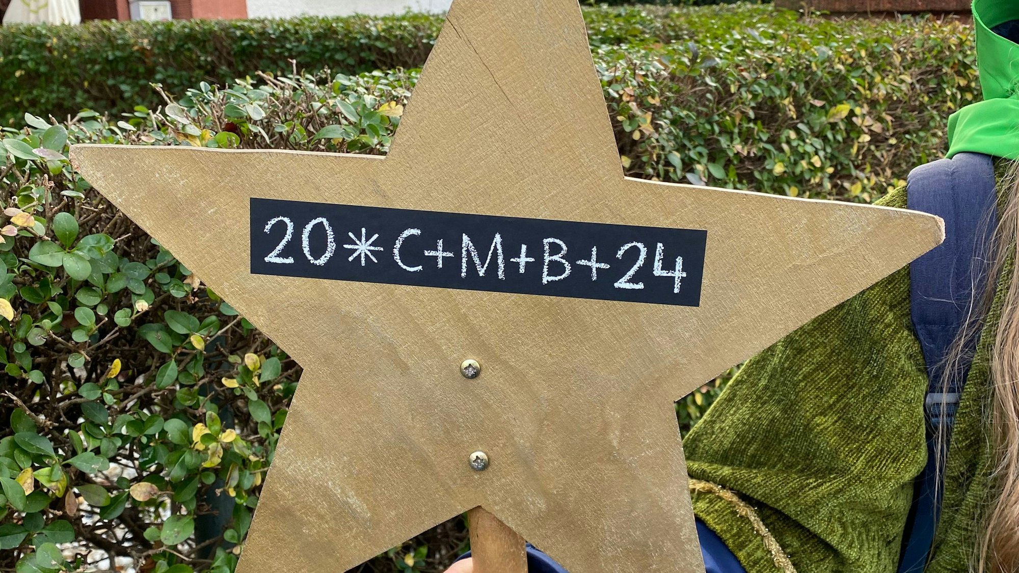 Stern aus Holz mit dem Segen der Sternsinger als Klebesegen darauf.