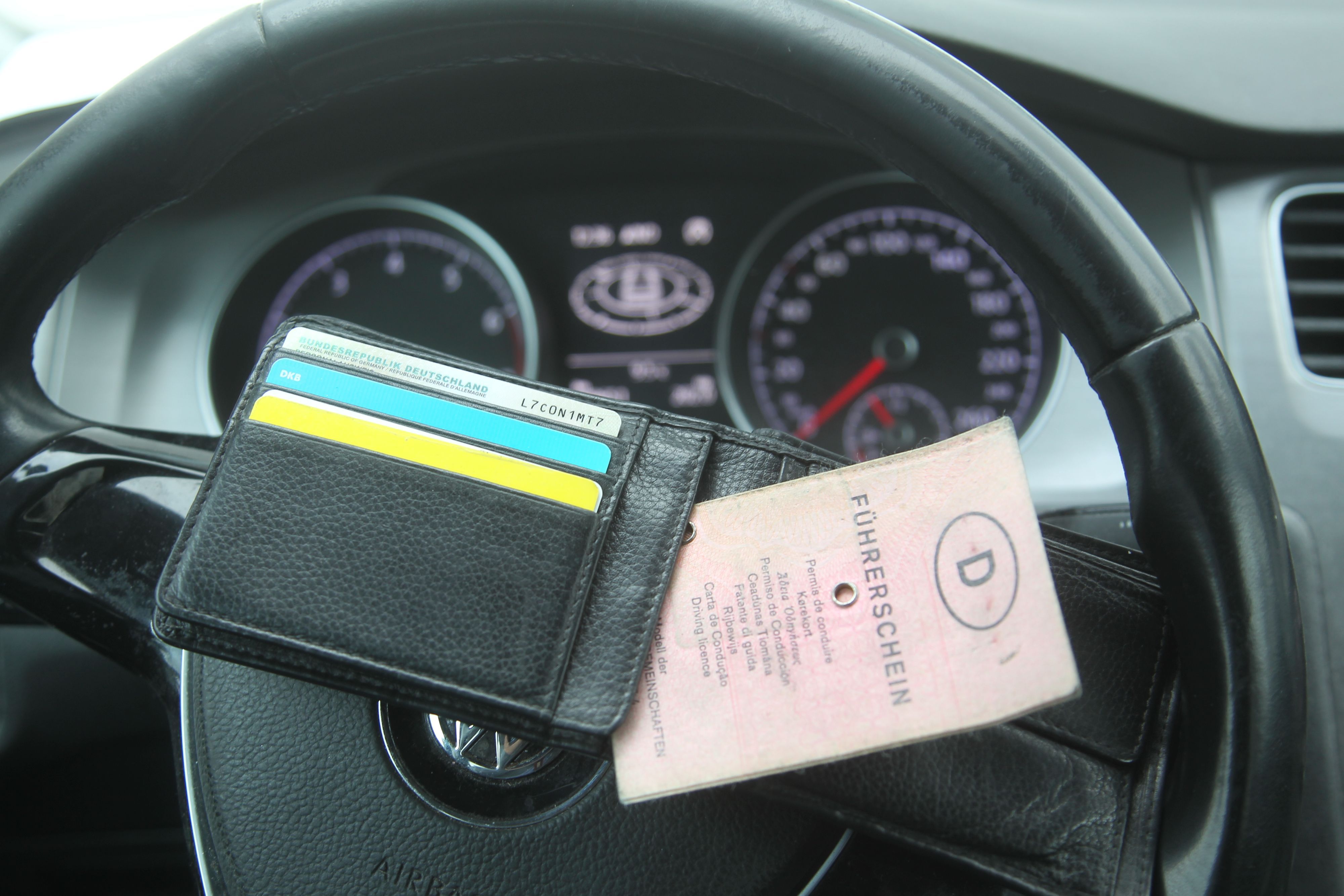 Ein Führerschein liegt auf einem Lenkrad.
