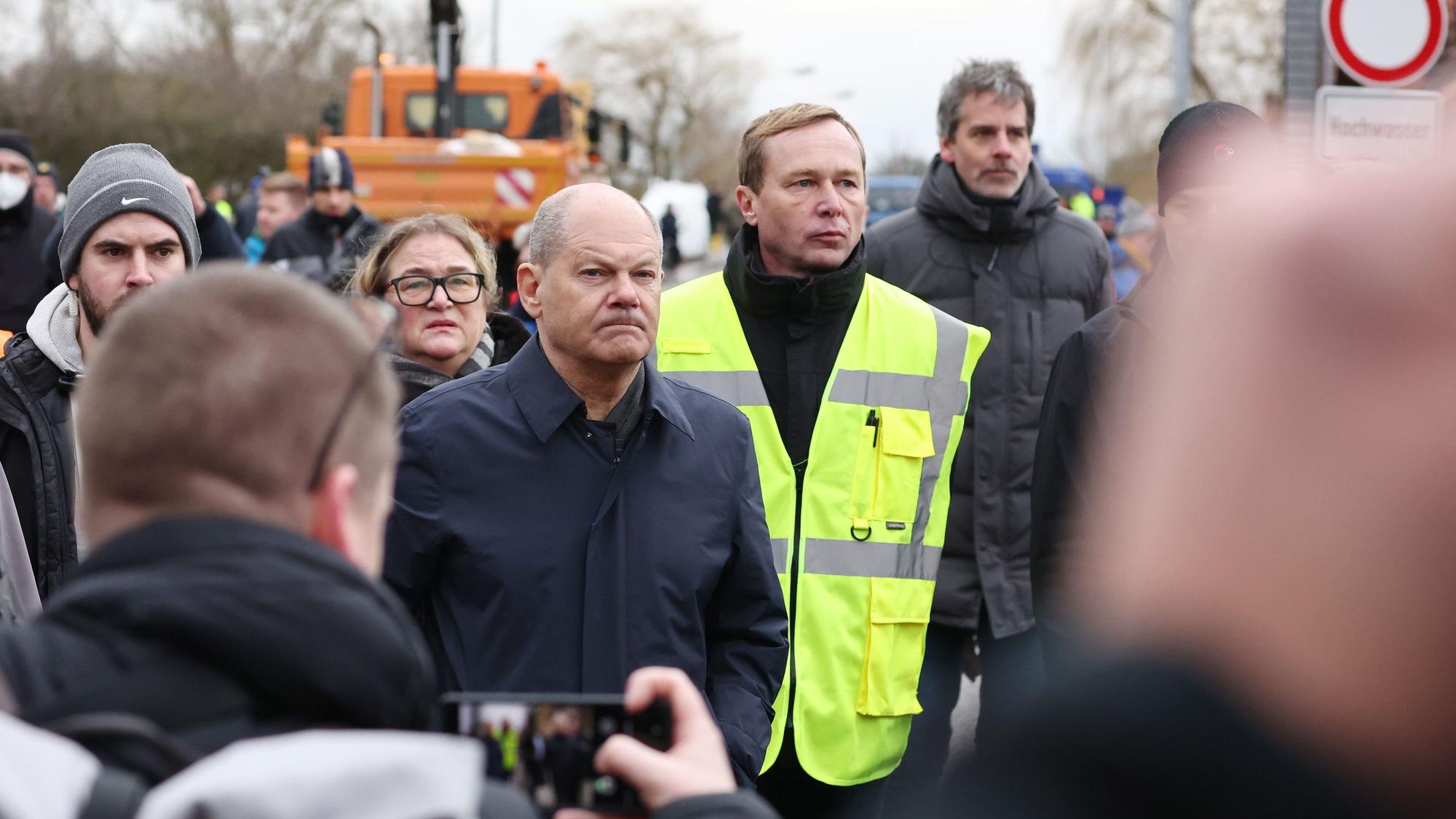 Bundeskanzler Olaf Scholz (M, SPD) und Sven Vogler (gelbe Weste), Leiter Katastrophenschutz Mansfeld-Südharz besichtigen Stellen in Sangerhausen, die vom Hochwasser betroffen sind.