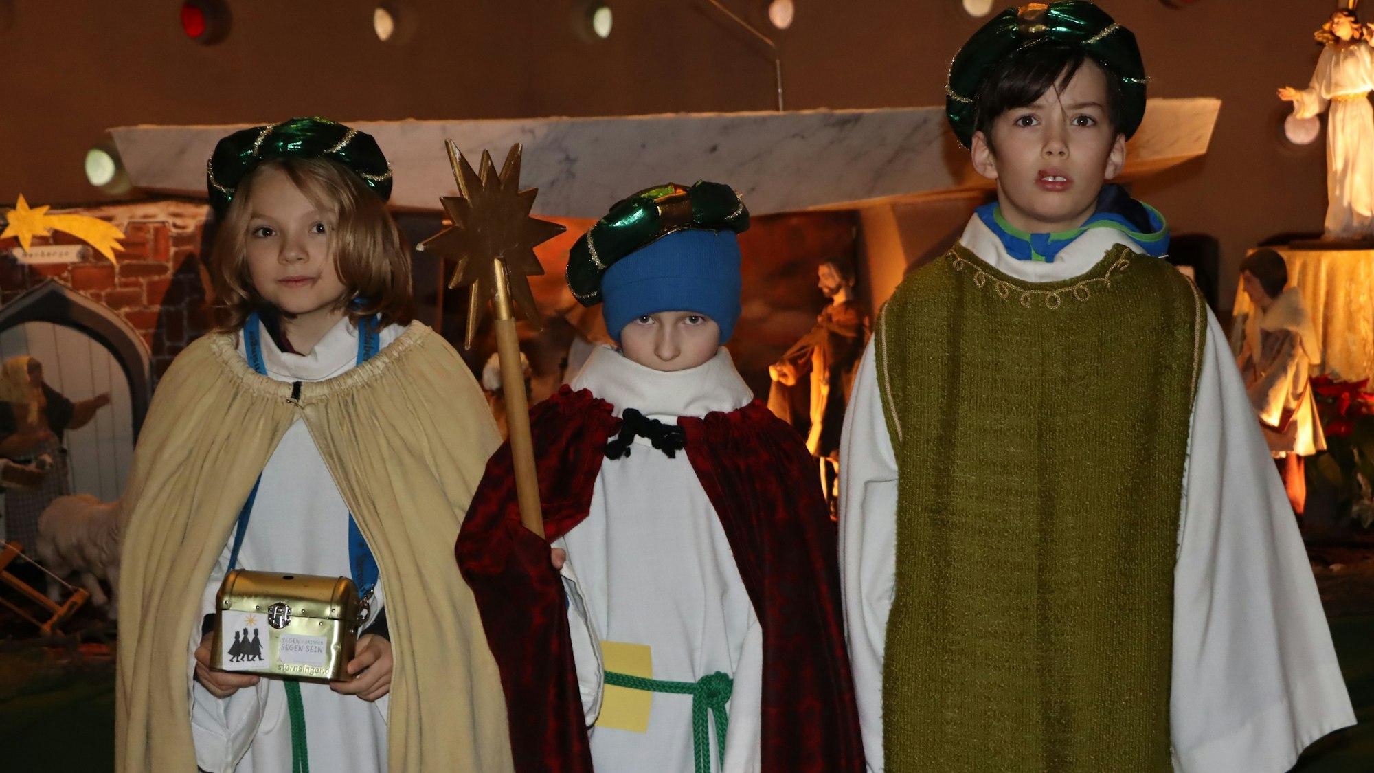 Zu sehen sind drei Kinder, die sich als Könige verkleidet haben.