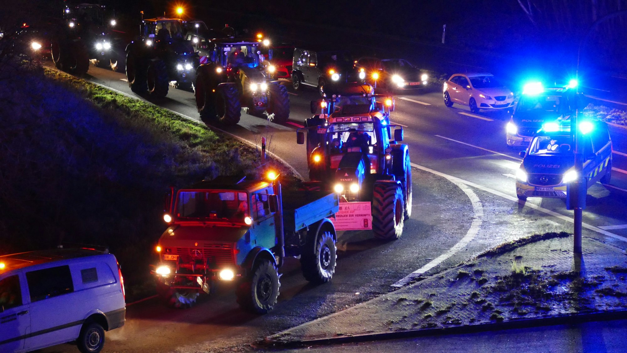 Beleuchtete Traktoren sind auf den Straßen im Rhein-Sieg-Kreis unterwegs. Das führt zu Staus im Straßenverkehr.