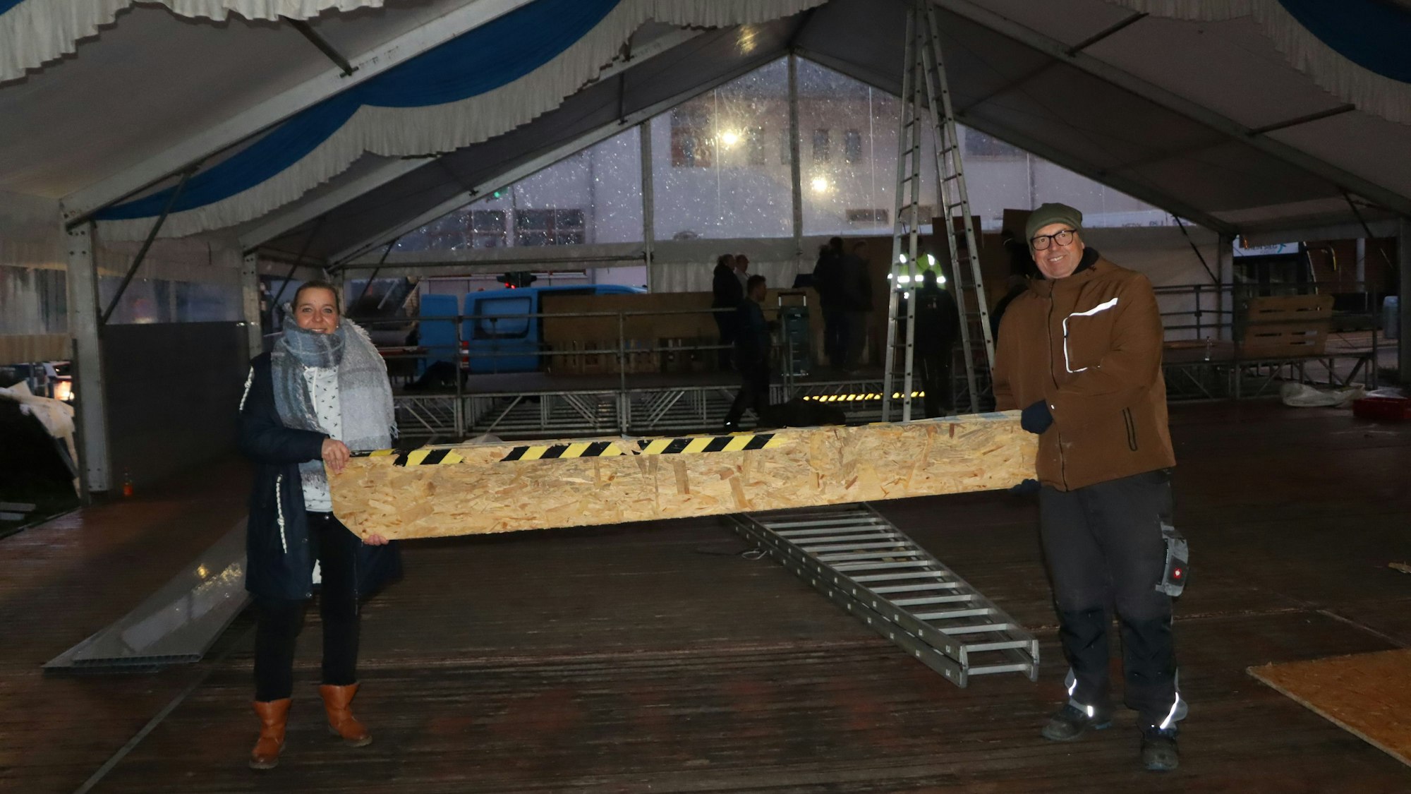 Frank Meurer und Claudia Packeisen tragen einen Teil der Bühne.