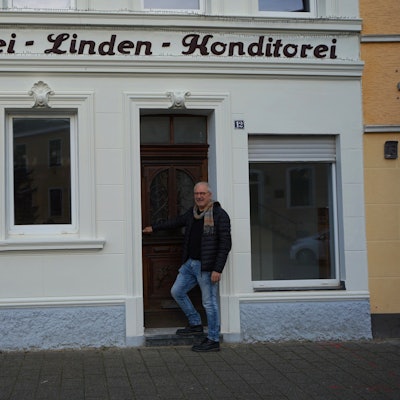 Ein Mann steht vor einem Gebäude.