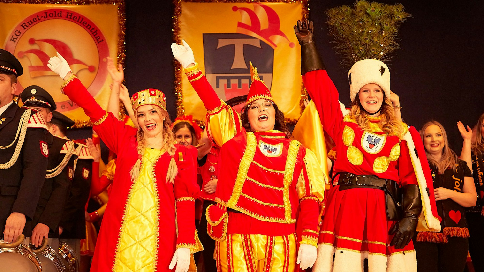 Die drei Frauen winken strahlend in den Saal.