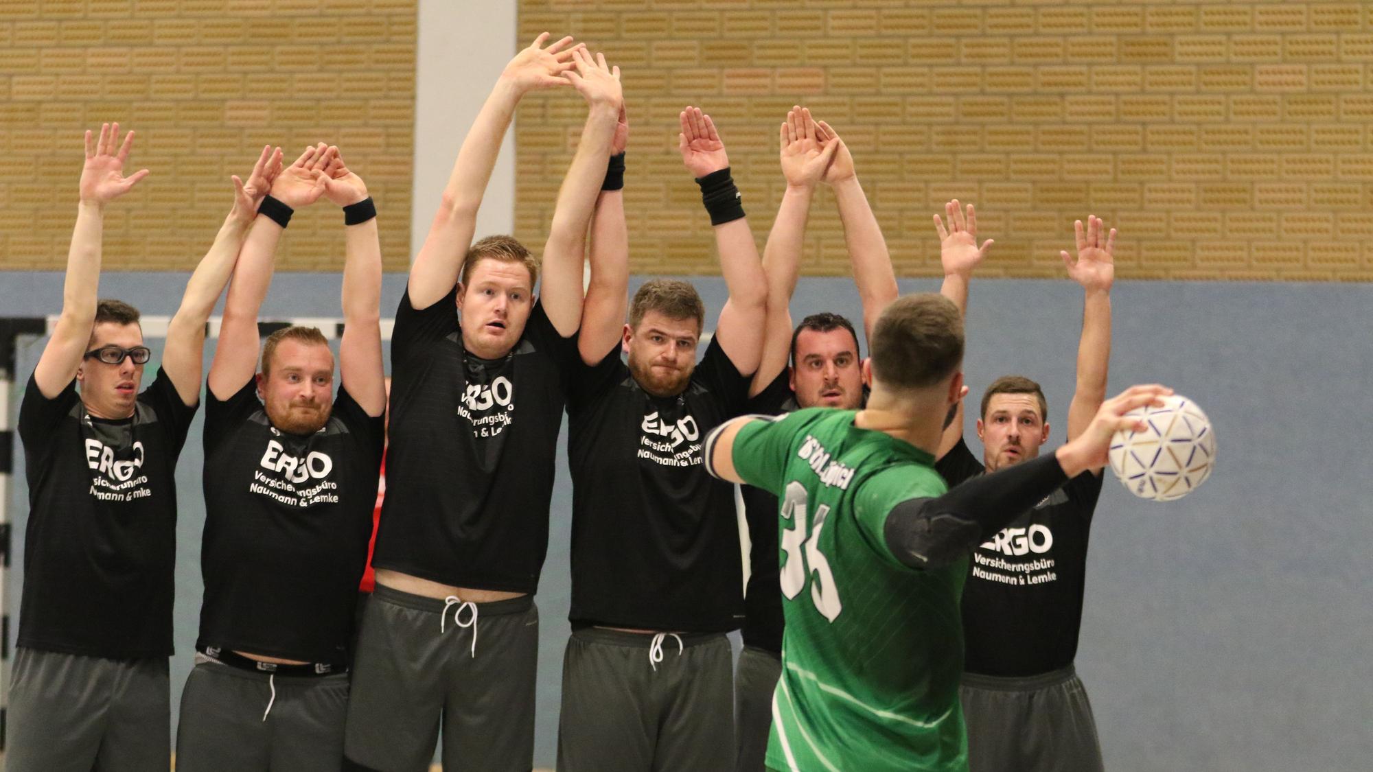 Der Kaller SC bildet eine Mauer, die Spieler reißen beim Freiwurf von Daniel Schüller die Arme hoch.