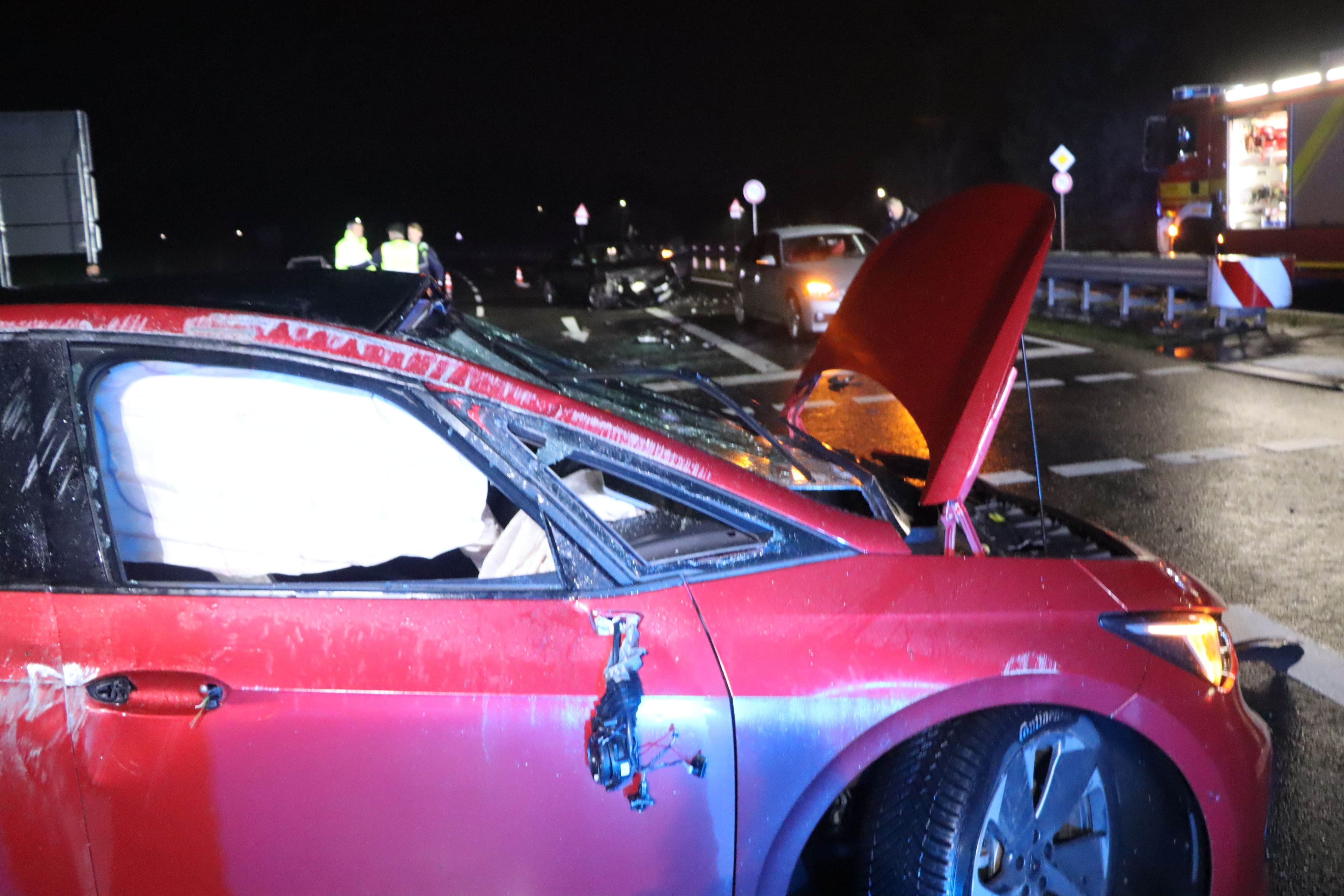 Feuerwehrleute fegen nach einem Unfall Glassplitter von einer Fahrbahn.