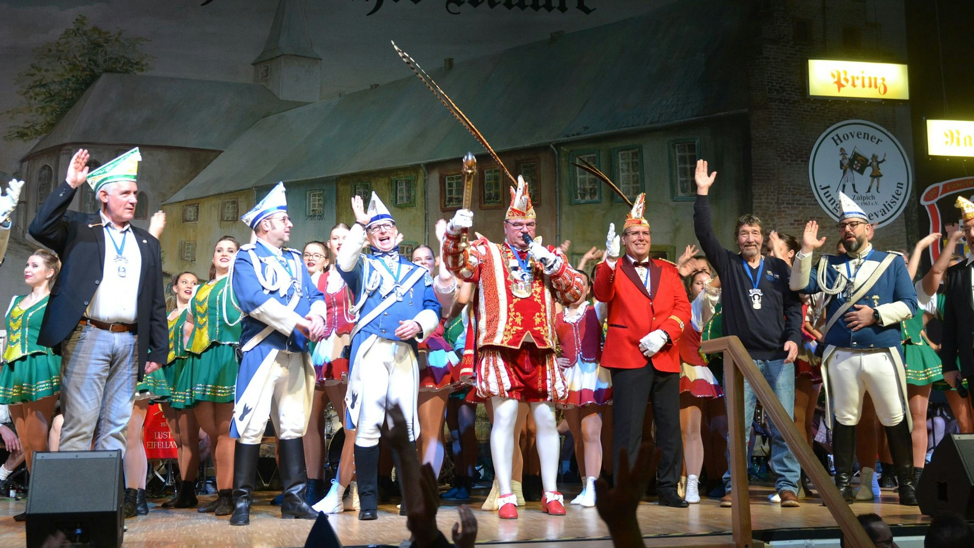 Der Zülpicher Prinz Ralf (Esser) und weitere Karnevalisten stehen auf der Bühne des Forums, die Arme zum Alaaf-Ruf in die Höhe gestreckt.