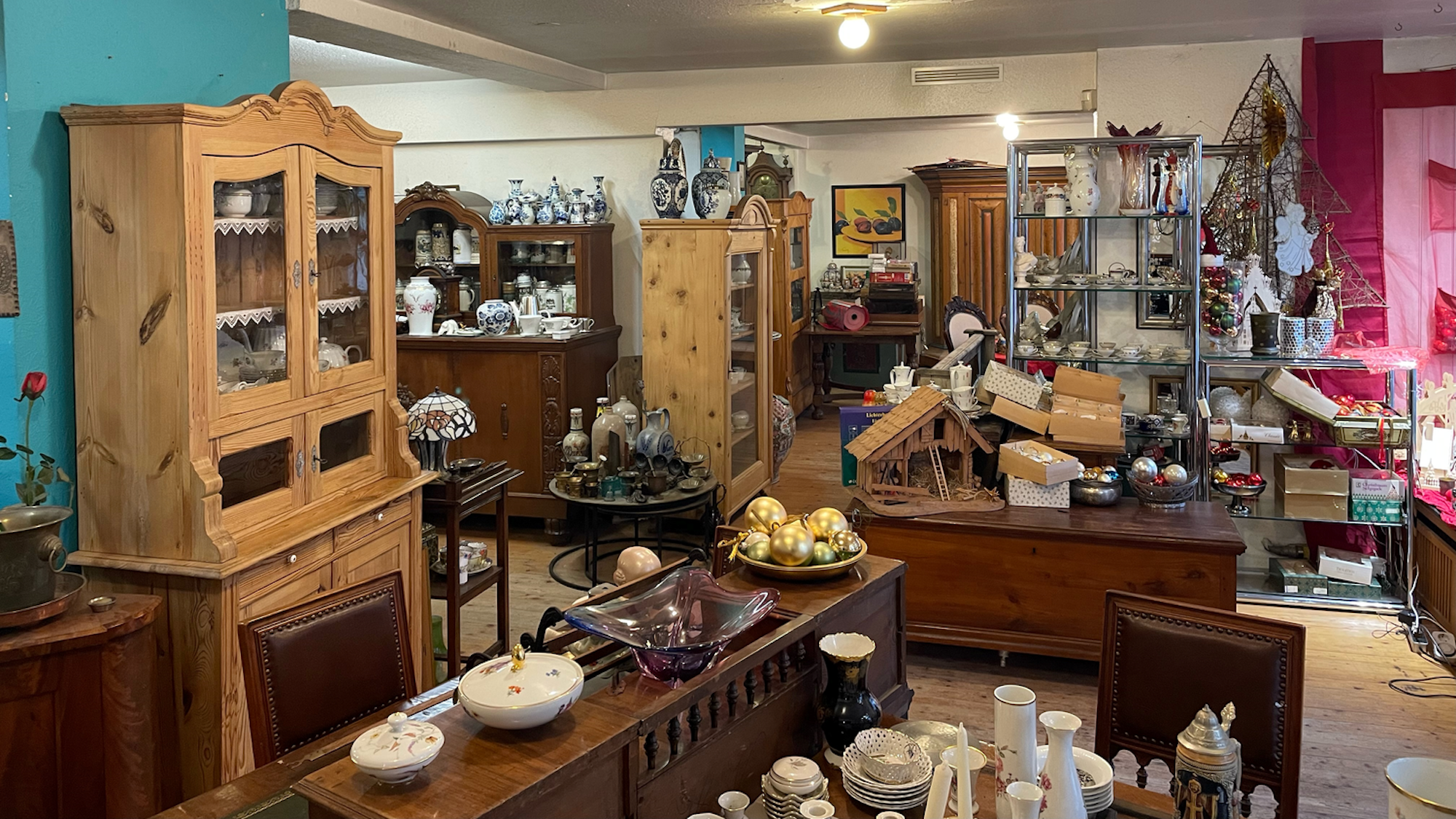Möbel, Geschirr und andere Gegenstände stapeln sich eng auf eng in einem Verkufsraum.
