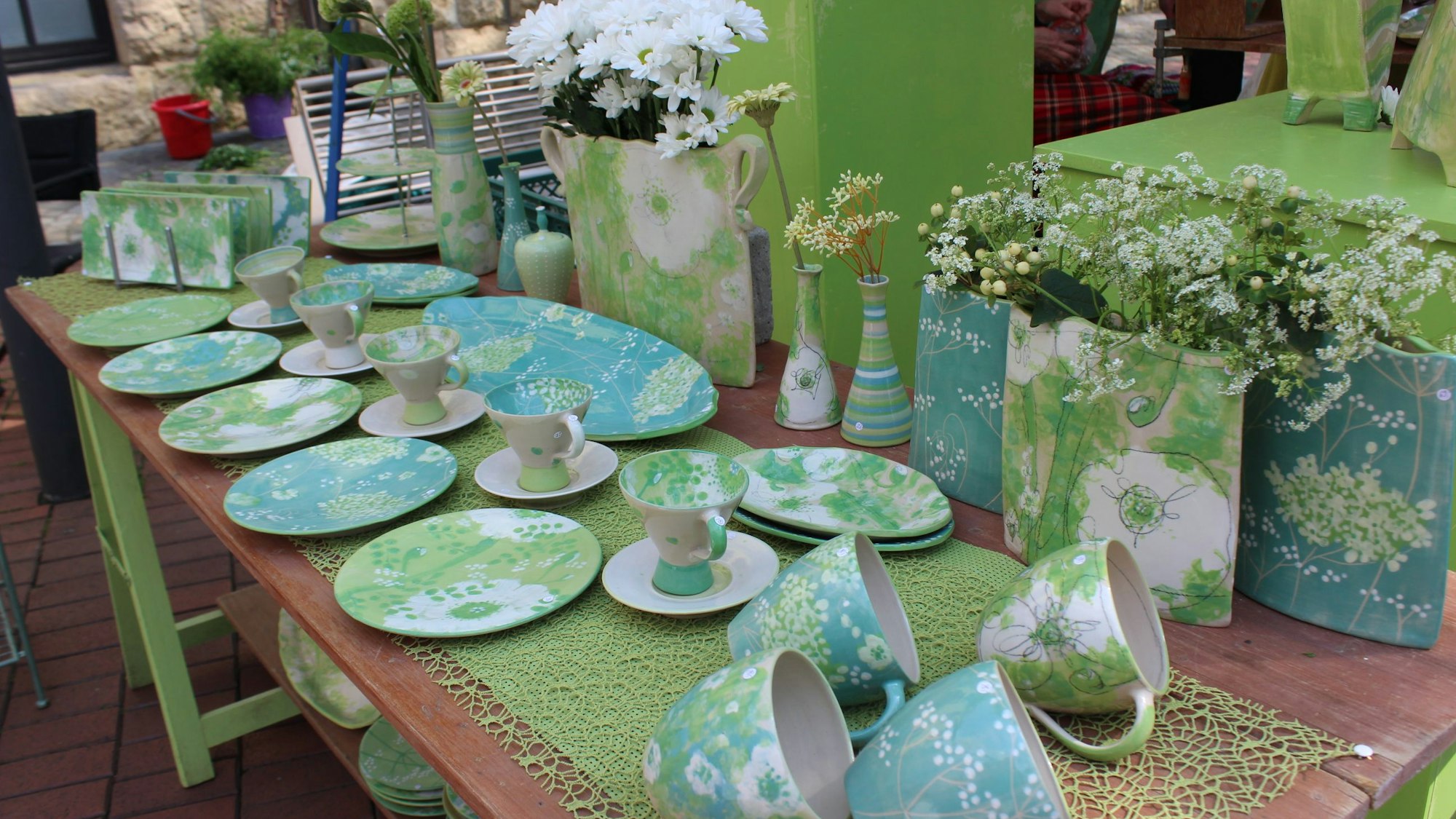 Auf dem Bild sind Becher und Teller aus Keramik zu sehen.