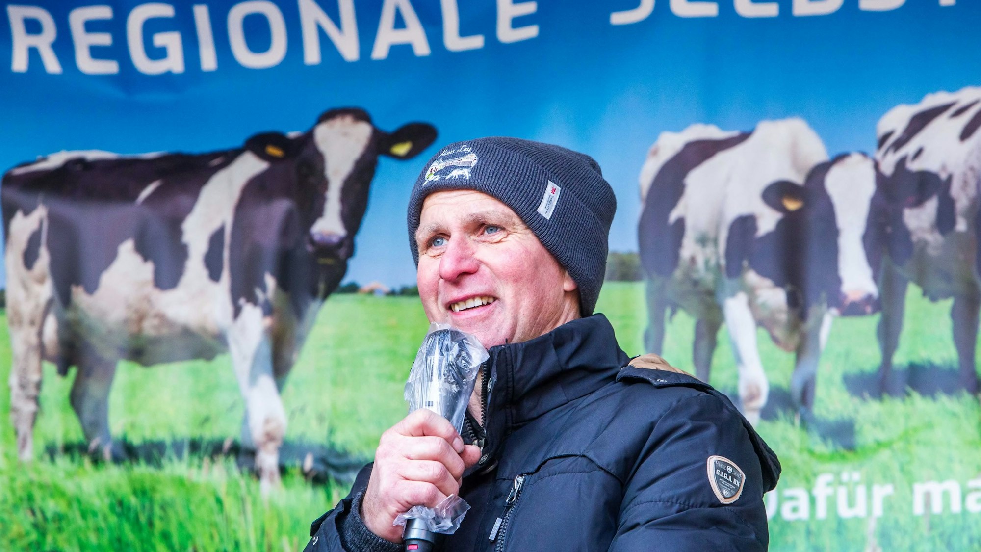 Foto eines Mannes, der von einer Bühne spricht