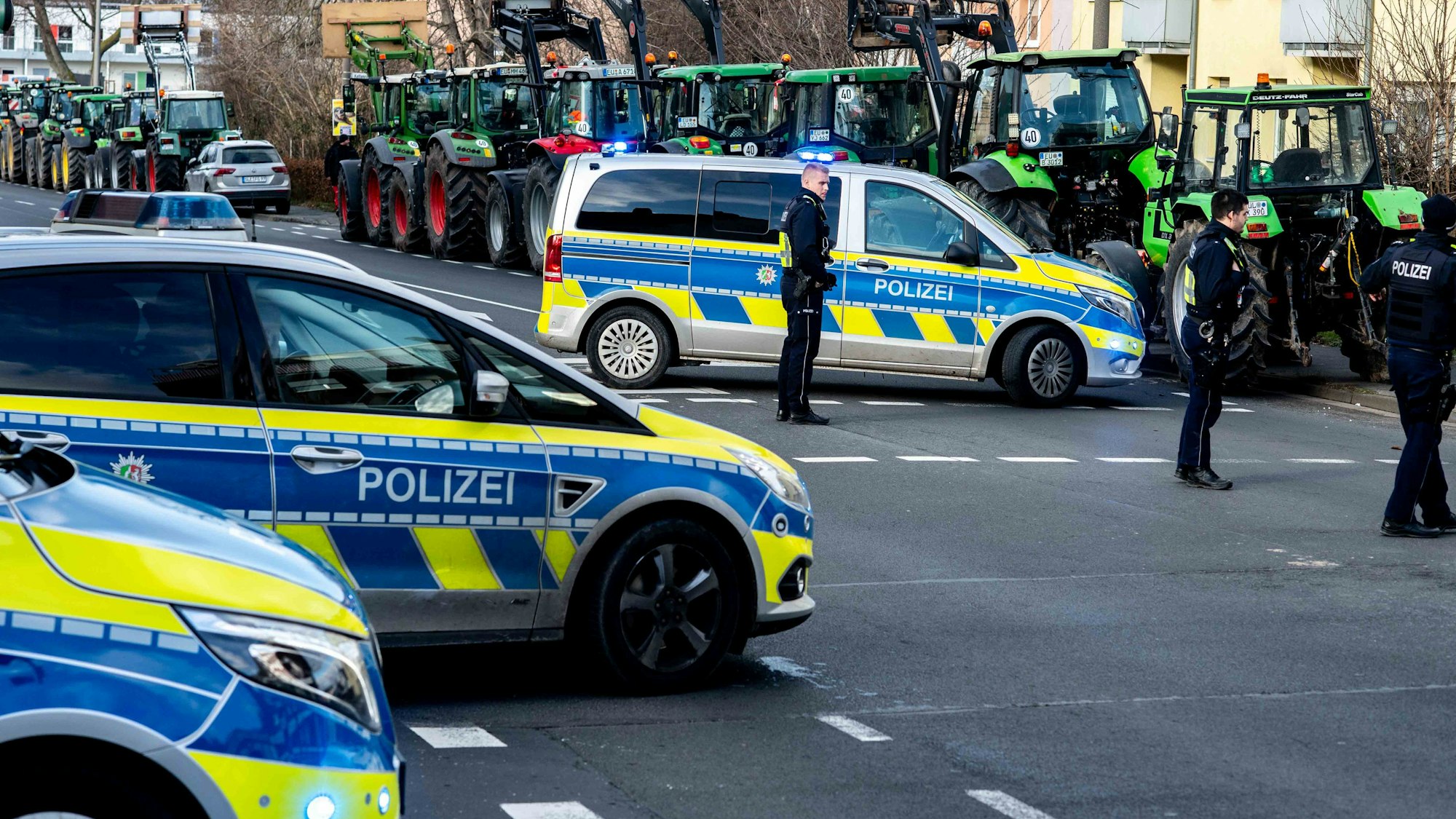 Das Bild zeigt einige Traktoren am Keltenring in Euskirchen. Die Polizei hat die Kreuzung mit drei Fahrzeugen abgesperrt.