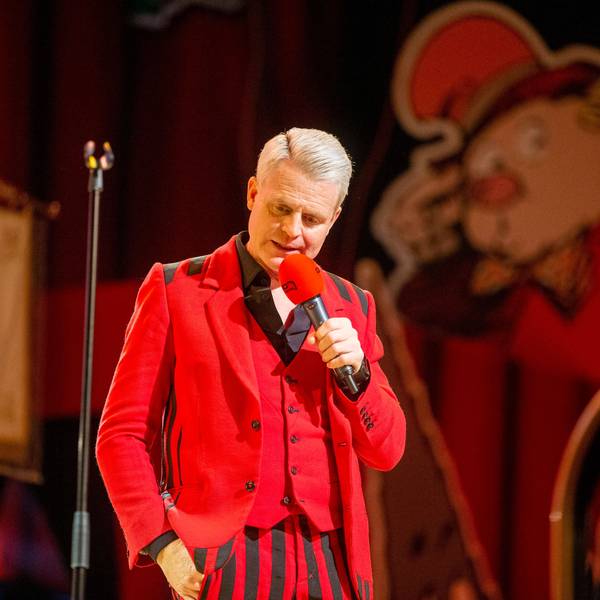 Guido Cantz im roten Maßanzug.