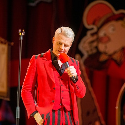 Guido Cantz im roten Maßanzug.