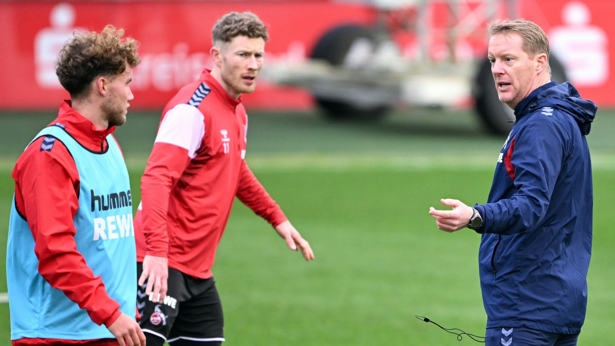 Timo Schultz (r), neuer Trainer des 1. FC Köln, spricht mit Florian Kainz (M) und Luca Waldschmidt (l).