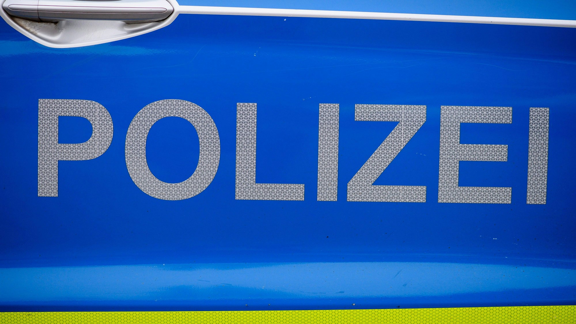 „Polizei“ ist auf einer Tür eines Polizeiautos zu lesen.