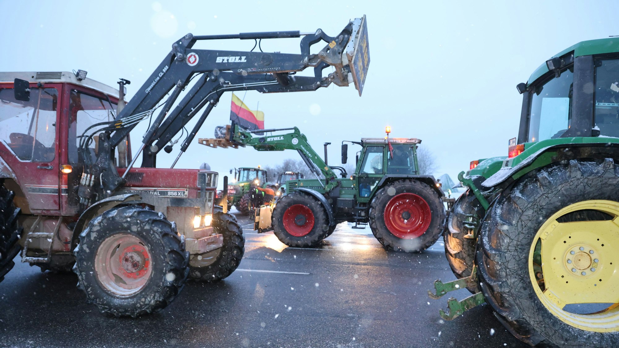 Die Treckerkorsos begegnen sich auf der B51. Einer der Traktoren ist mit einer Deutschlandfahne geschmückt.