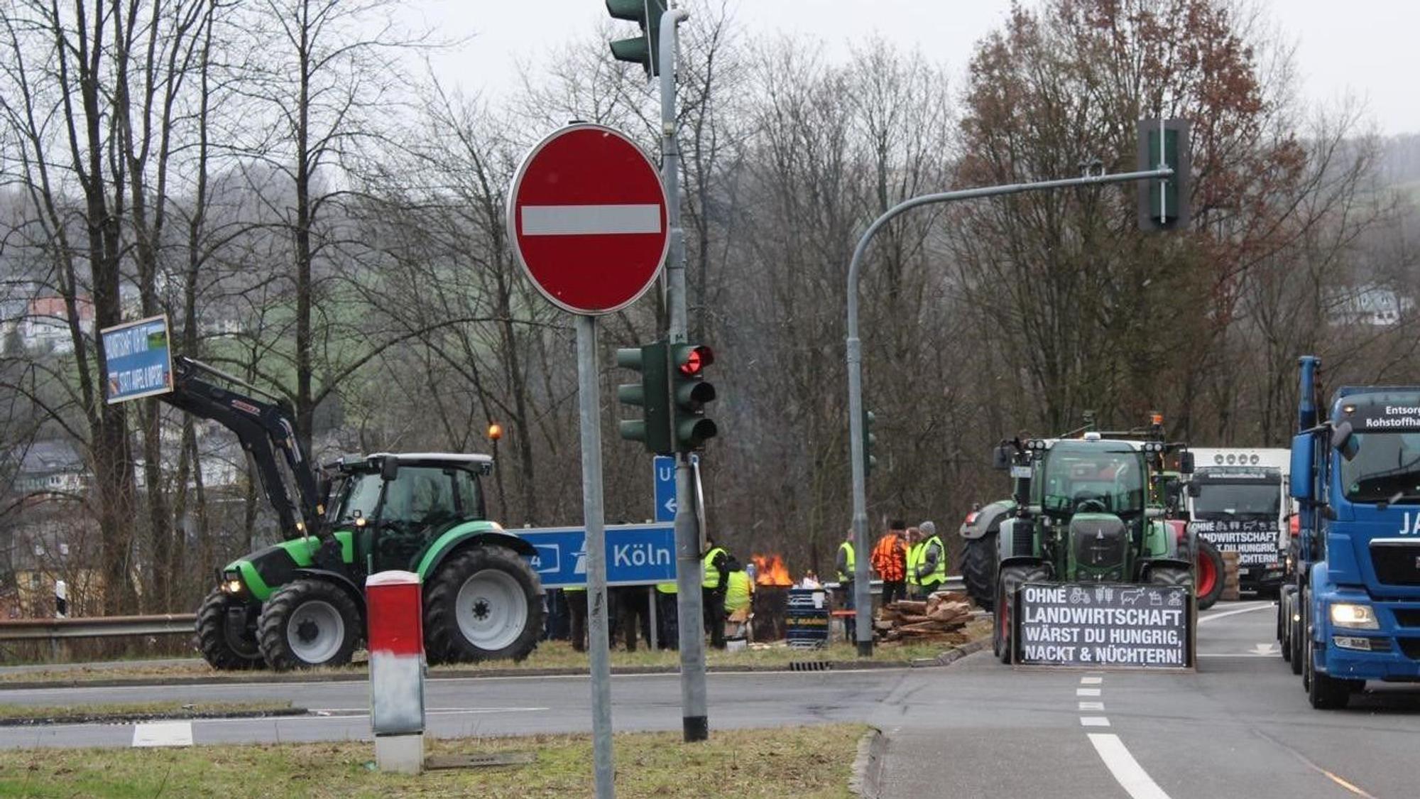 Einige Landwirte postieren sich mit einer Feuertonne an einer Autobahnauffahrt.