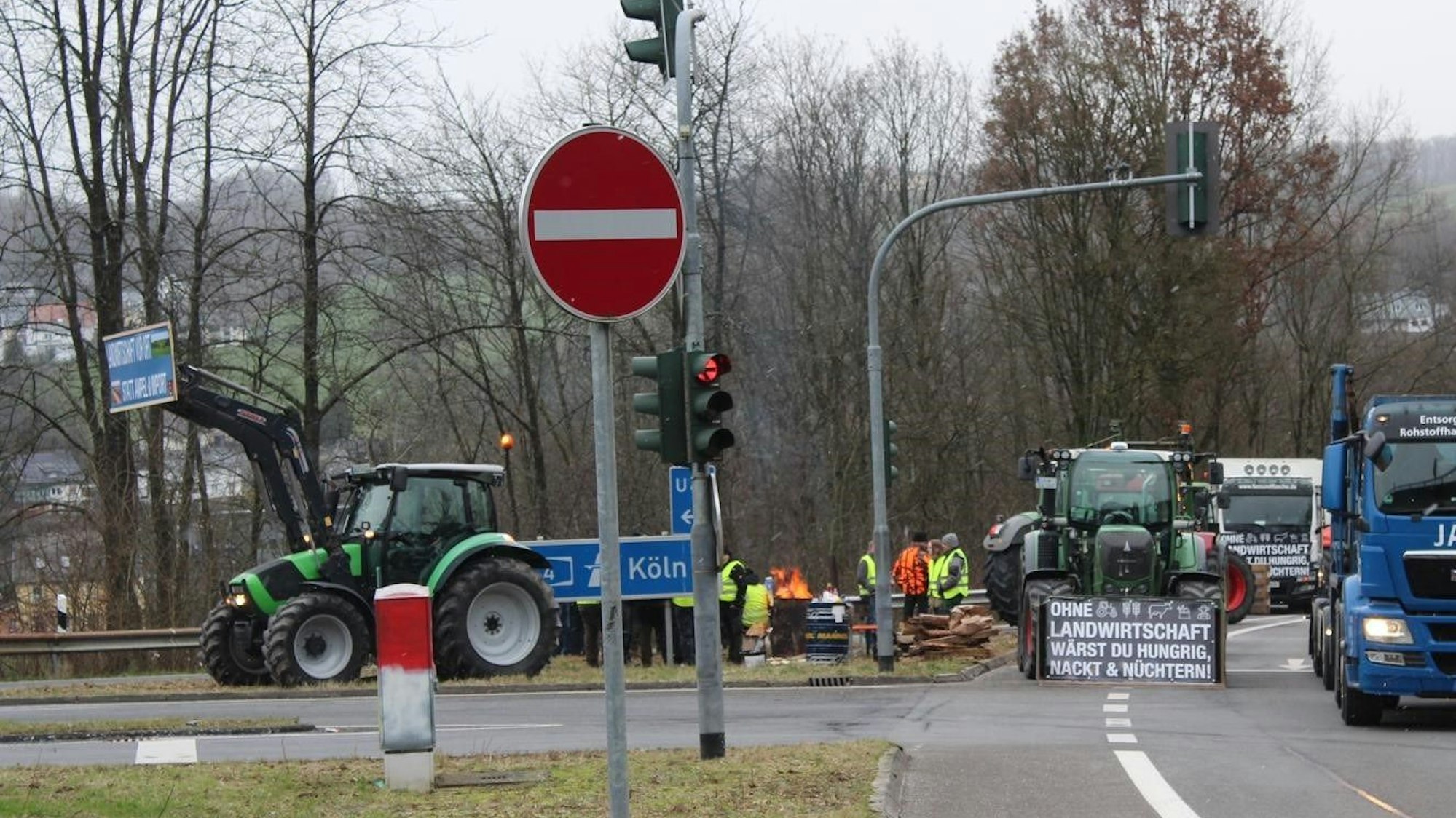 Einige Landwirte postieren sich mit einer Feuertonne an einer Autobahnauffahrt.