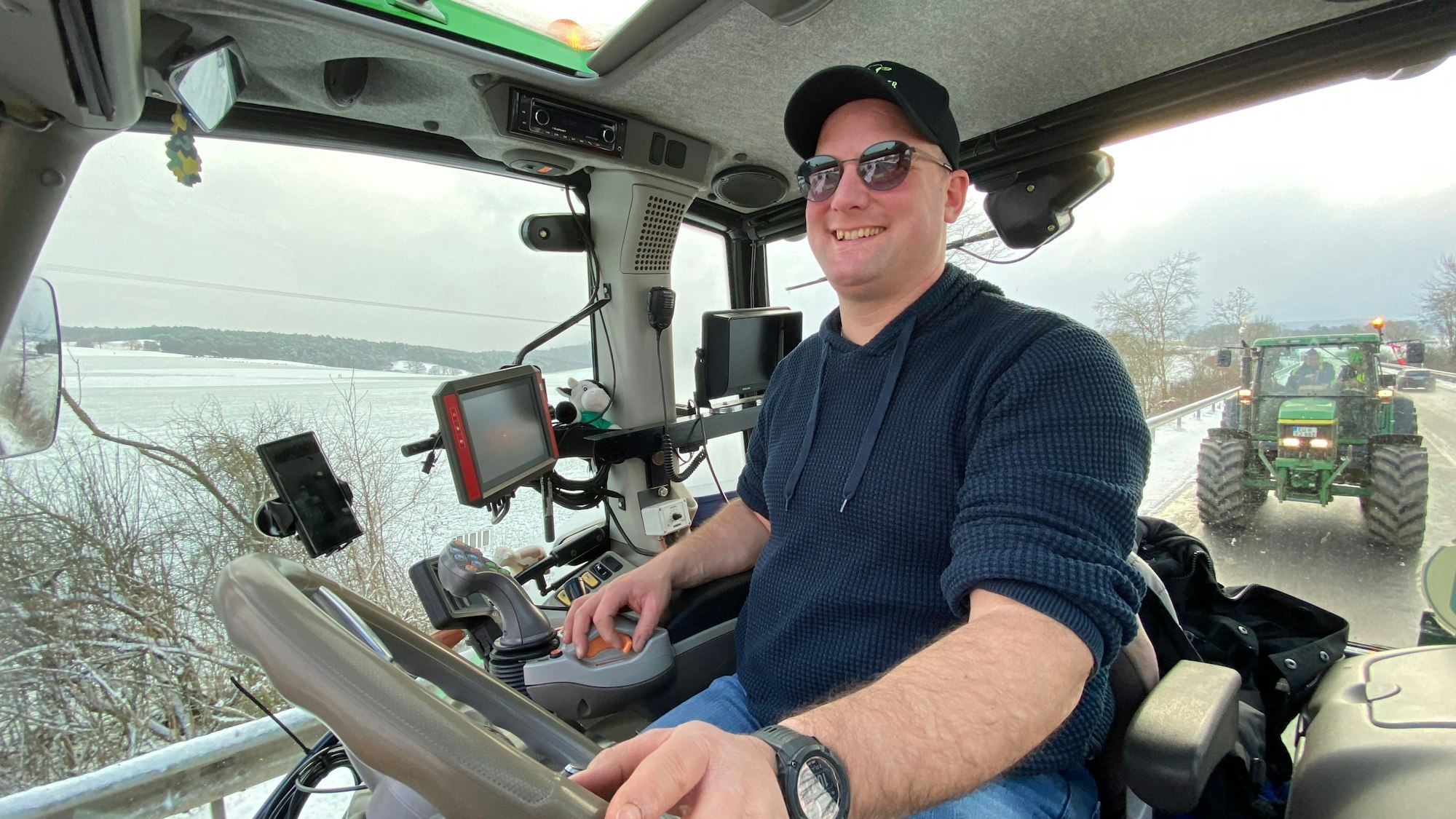 Landwirt Sebastian Bützler sitzt in seinem Trecker. Hinter ihm folgt ein weiterer Trecker.