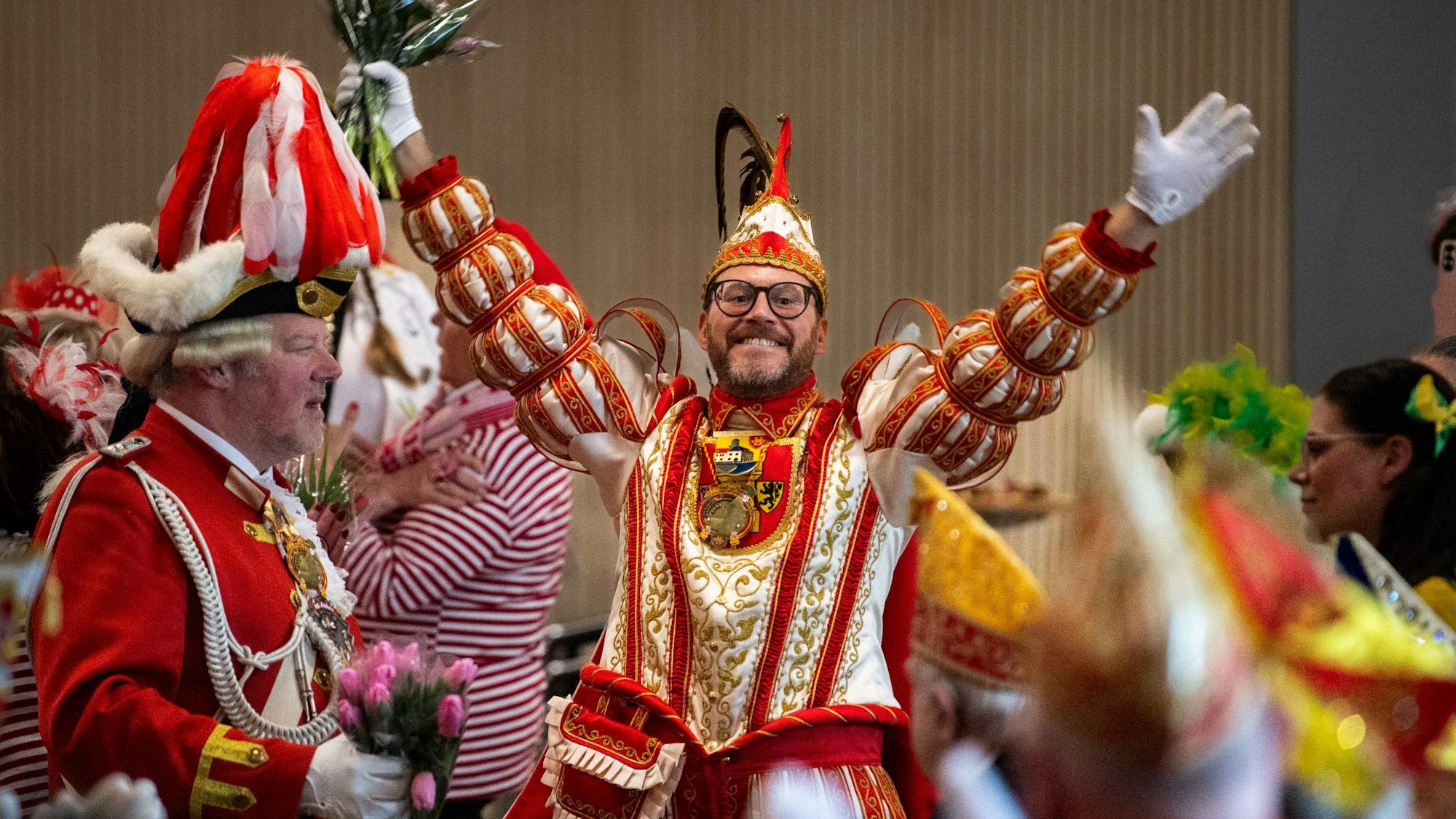 Das Bild zeigt Tobias Wiesen im Prinzen-Ornat, wie er kurz nach dem Einzug die Arme nach oben reißt und über beide Ohren strahlt.