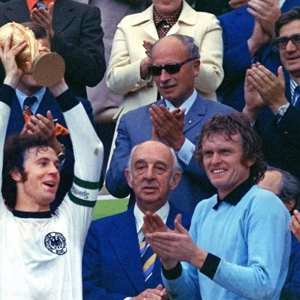 Franz Beckenbauer hebt einen Pokal in die Luft.