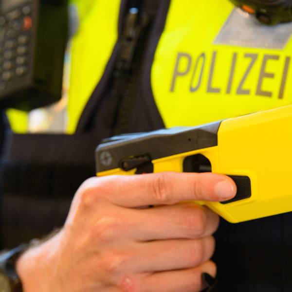 Ein Polizeibeamter hält einen Taser 7 in der Hand.