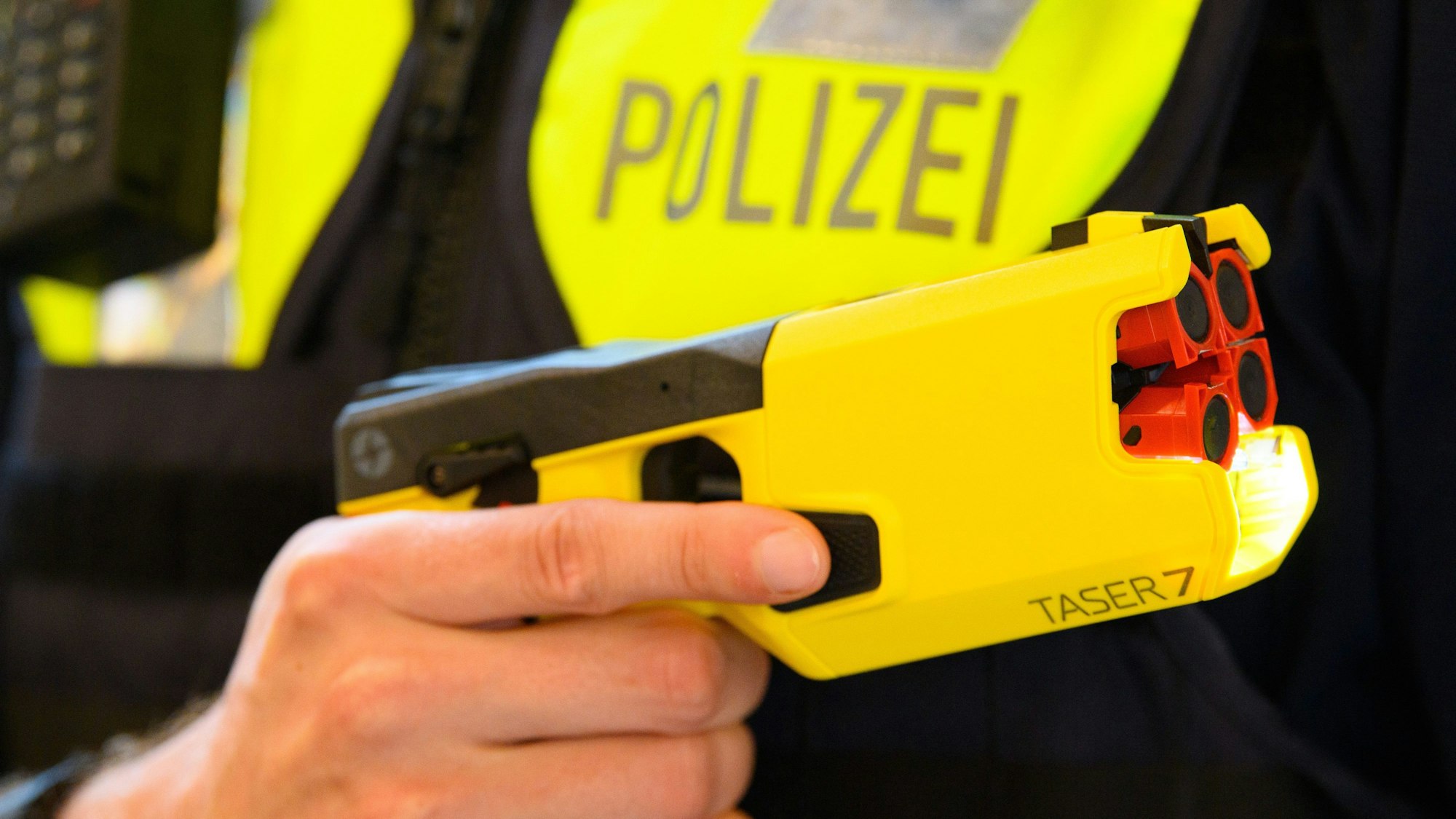 Ein Polizeibeamter hält einen Taser 7 in der Hand.