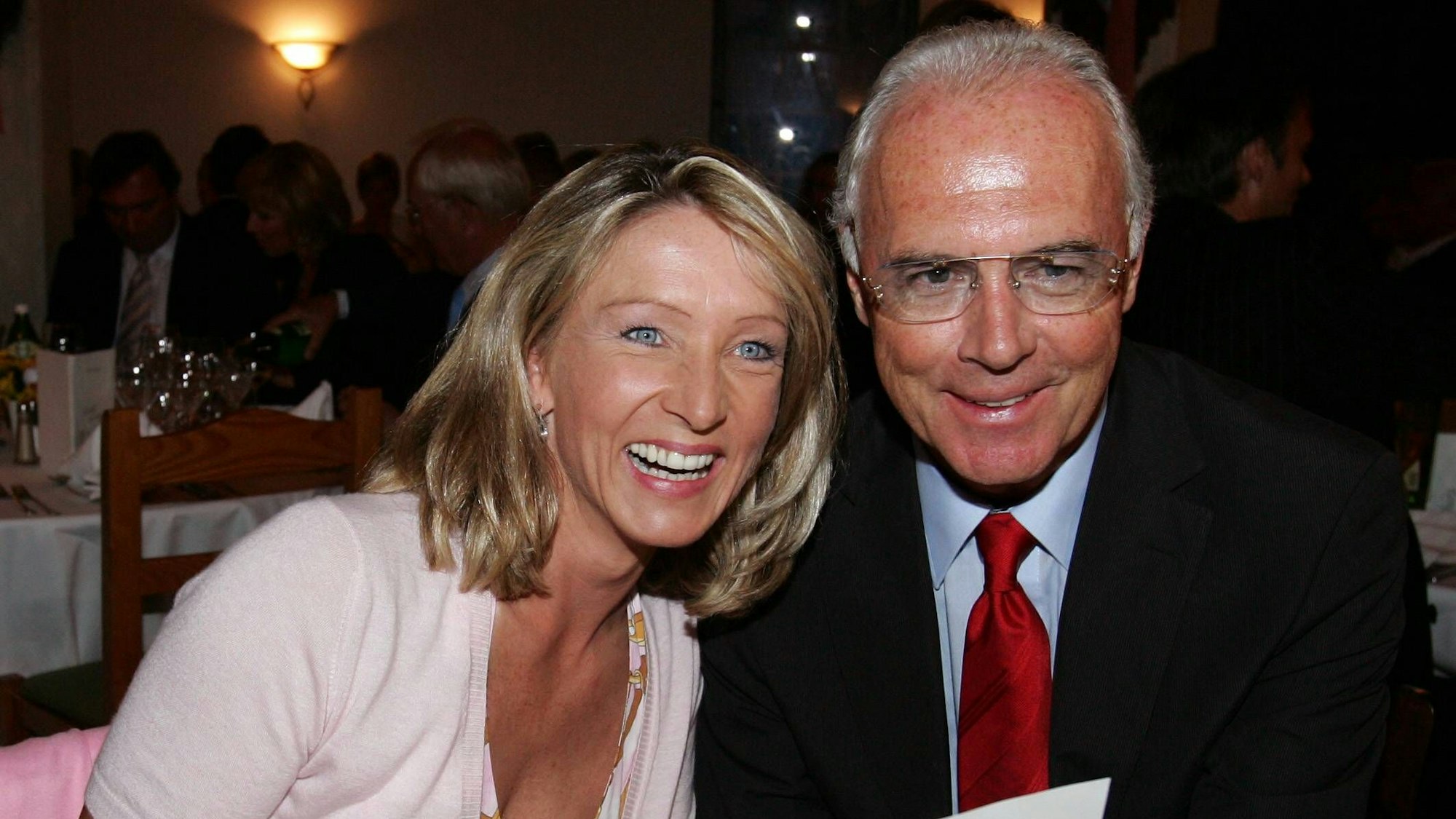 Franz Beckenbauer und Heidrun Burmester sehen sich gemeinsam die Speisekarte an.
