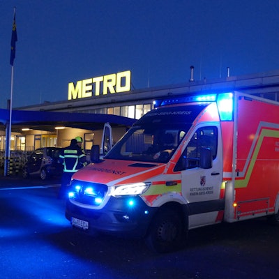 Ein Rettungswagen steht vor einem Großmarkt.
