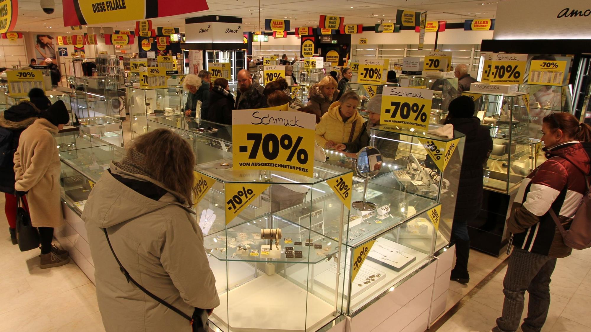 Kunden vor fast leeren Verkaufsvitrinen in einem Warenhaus