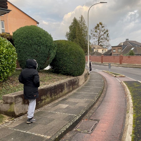 Zu sehen ist die Schulstraße in Kierberg, die eine Kurve beschreibt und über einen abgetrennten Radstreifen verfügt.