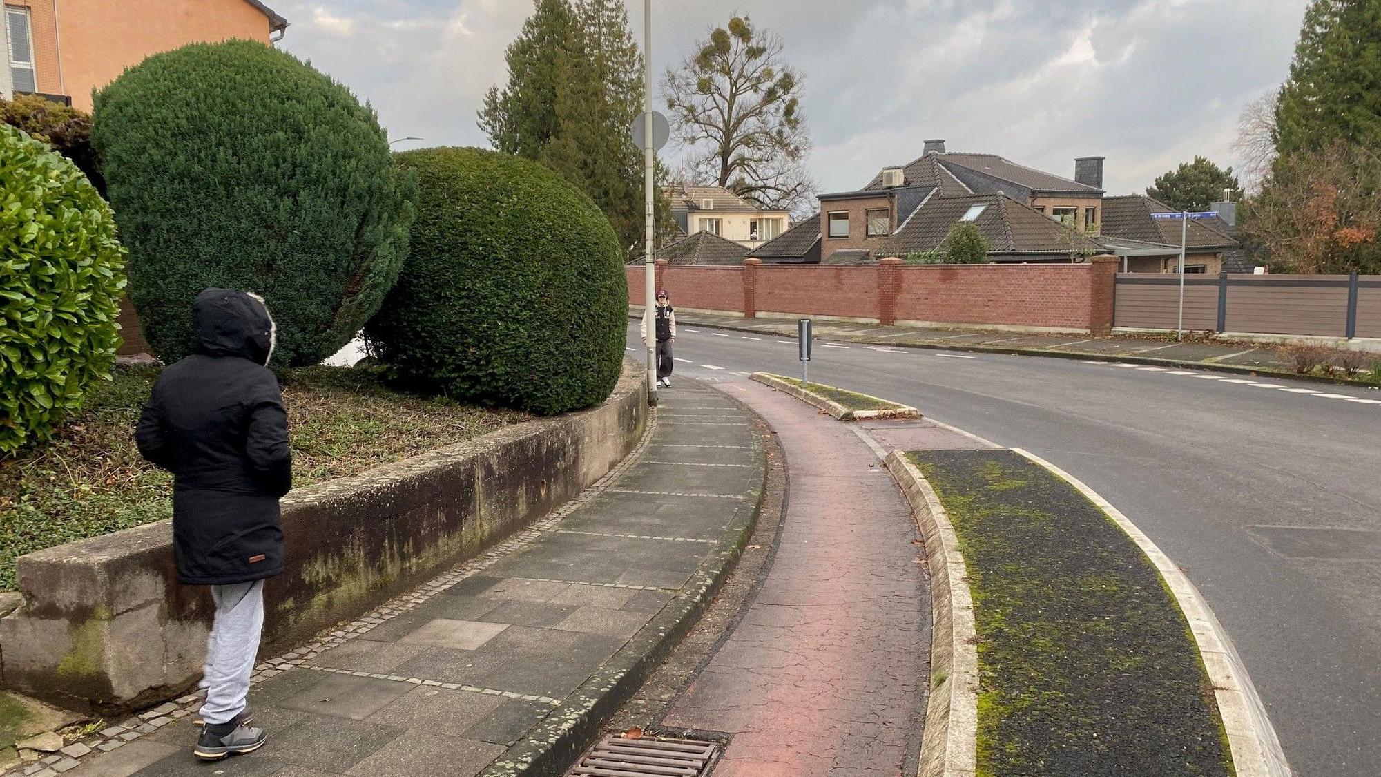 Zu sehen ist die Schulstraße in Kierberg, die eine Kurve beschreibt und über einen abgetrennten Radstreifen verfügt.