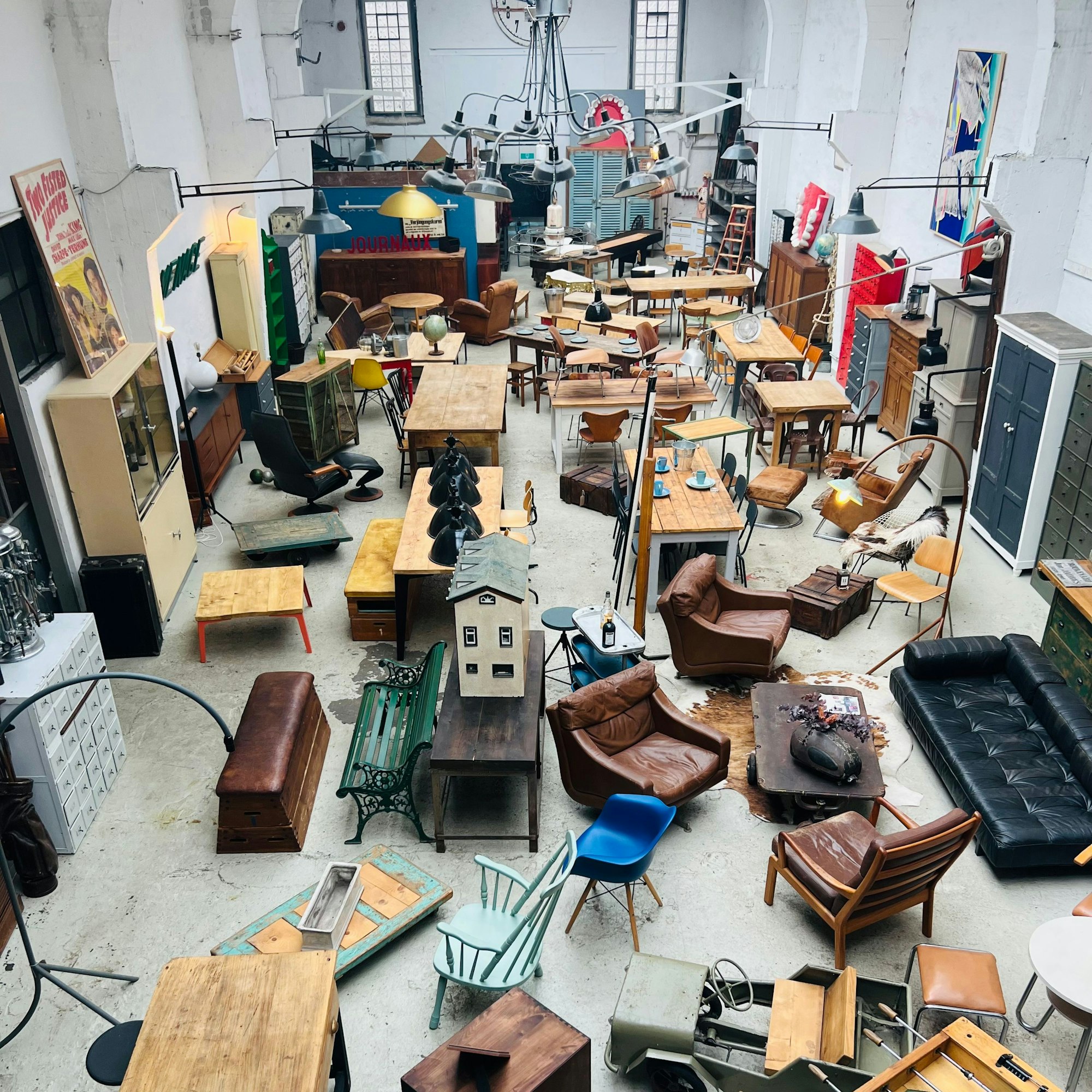 In einer großen Halle stehen viele alte Möbel