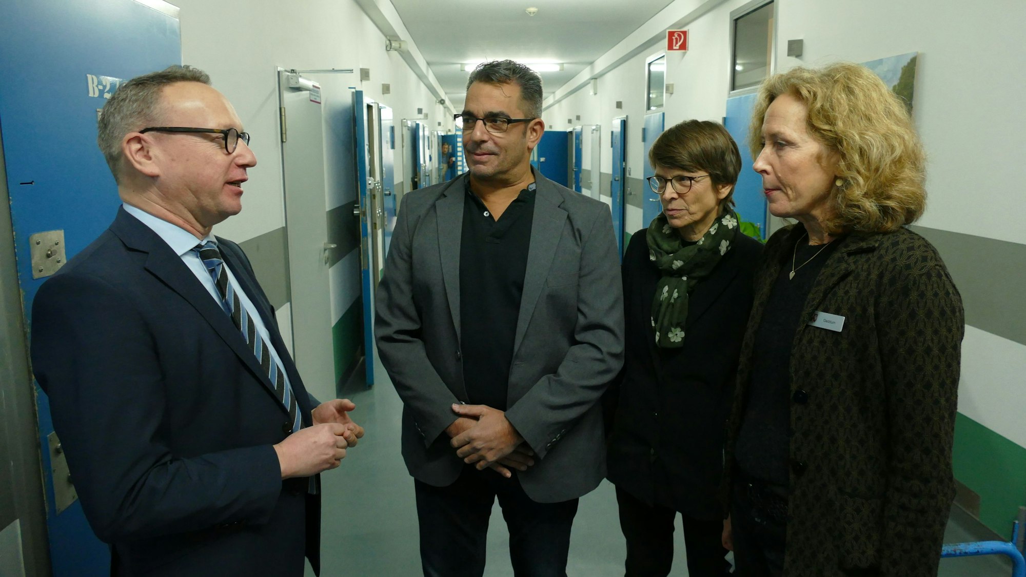 NRW-Justizminister Benjamin Limbach, Andreas Scheerer von der Suchtprävention, Caroline Ströttchen (Justizministerium) und Renate Gaddum, Leiterin der JVA Rheinbach (v.l.) stehen in einem Trakt der JVA Rheinbach.
