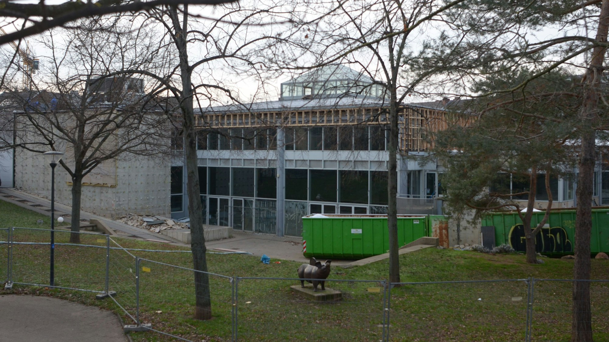 Vor dem City-Forum, das abgebrochen werden soll, stehen Container für den Abtransport von Baustoffen. Teile der Fassade sind schon demontiert worden. Das Gelände ist von einem Bauzaun umgeben.