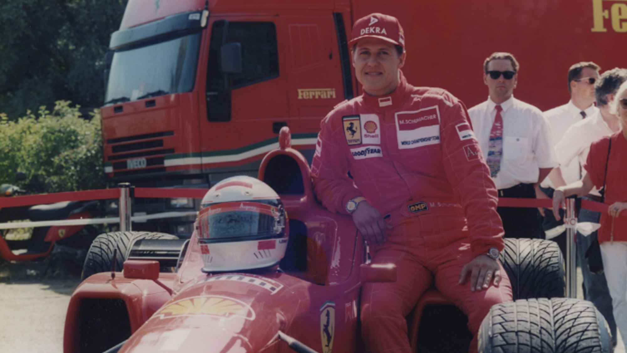 Michael Schumacher lehnt sich an einen Ferrari.