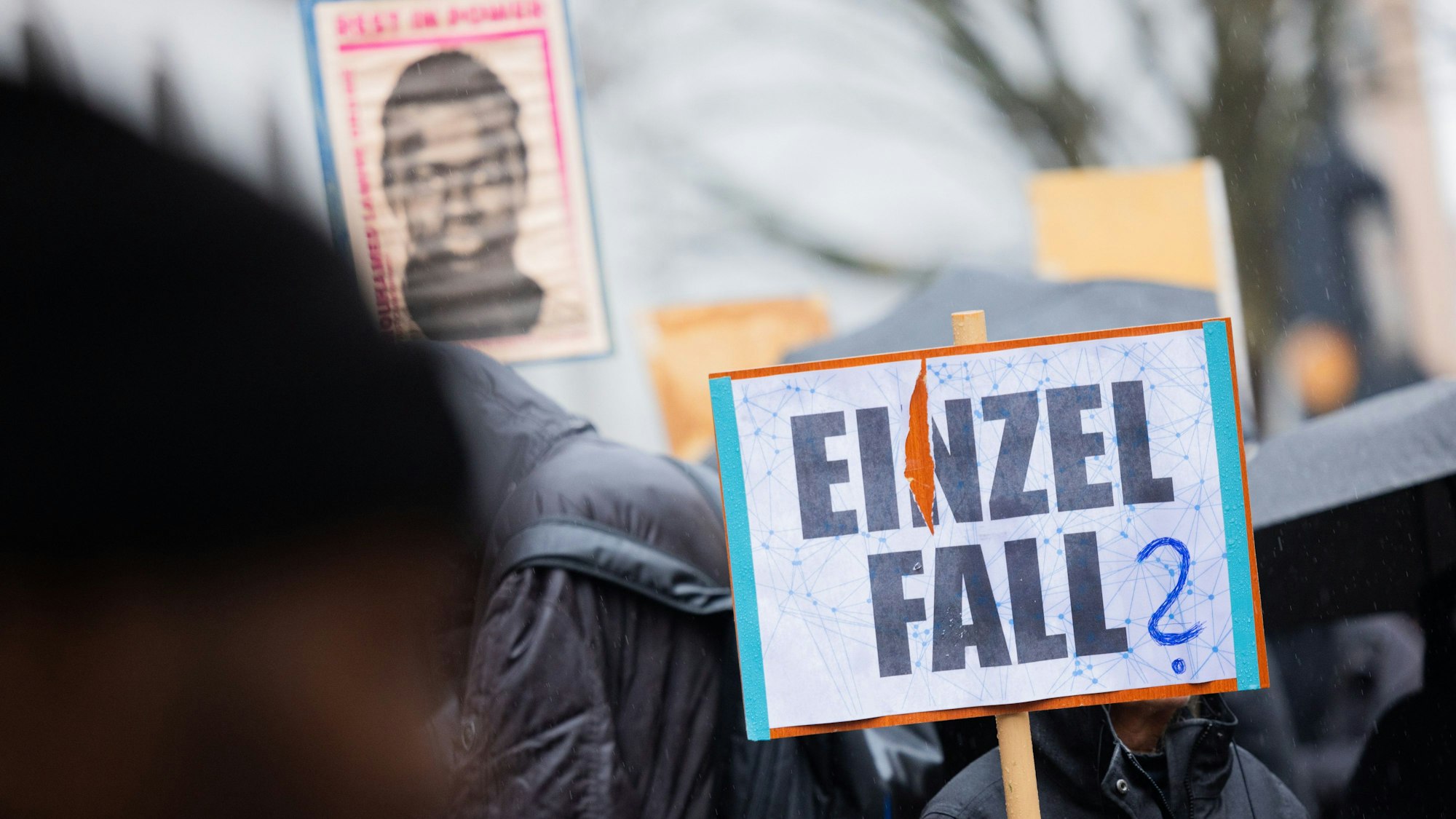 Demonstranten stehen mit Plakaten, die das Portrait des 16-jährigen Senegalesen Mouhamed Drame zeigen, vor dem Landgericht. Hier beginnt der Prozess nach tödlichen Polizeischüssen auf den jungen Flüchtling.