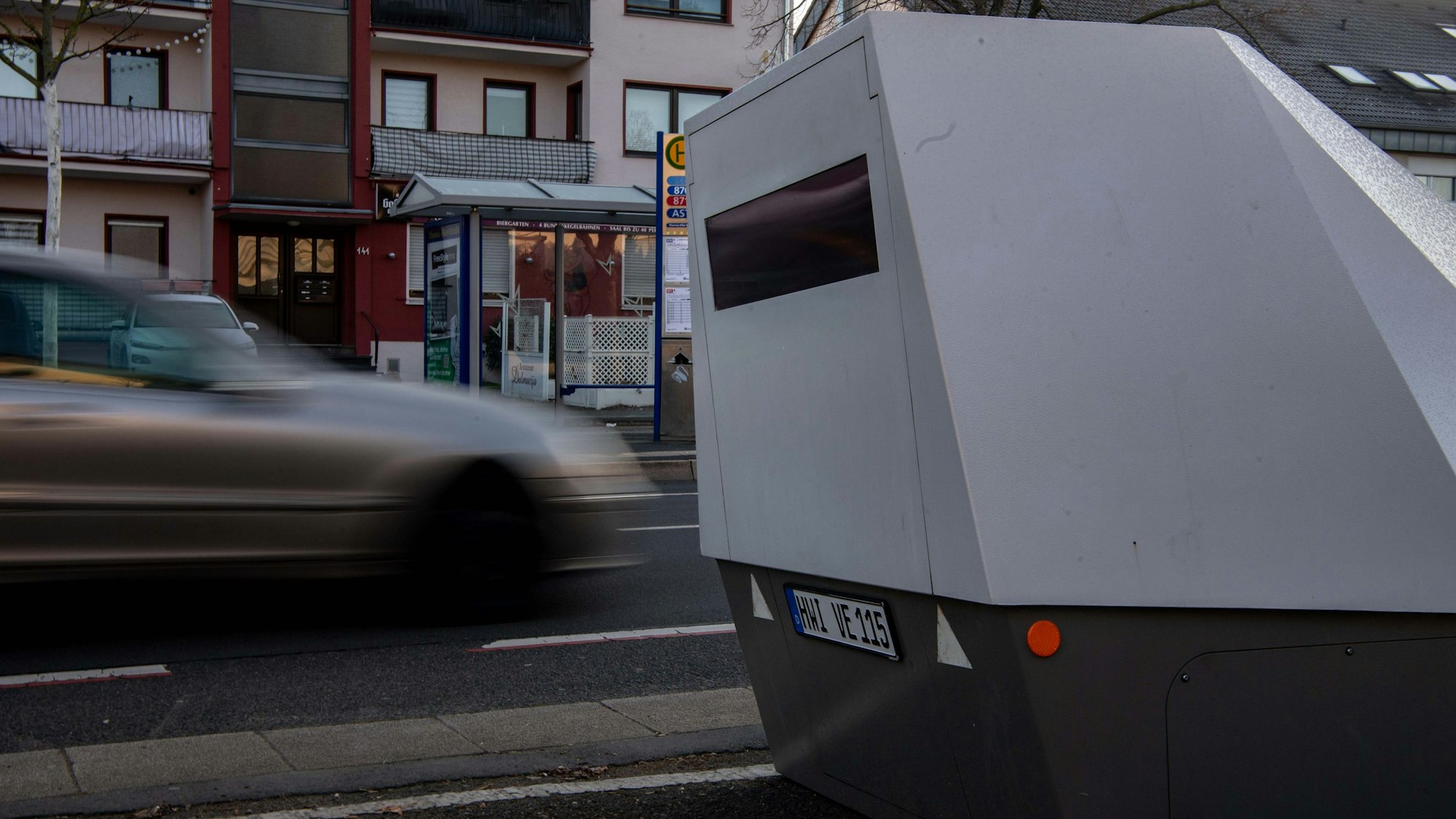 Das Bild zeigt den Blitzer am aktuellen Standort an der Münstereifeler Straße. Im Hintergrund fährt ein Auto vorbei. Es ist nicht zu schnell.