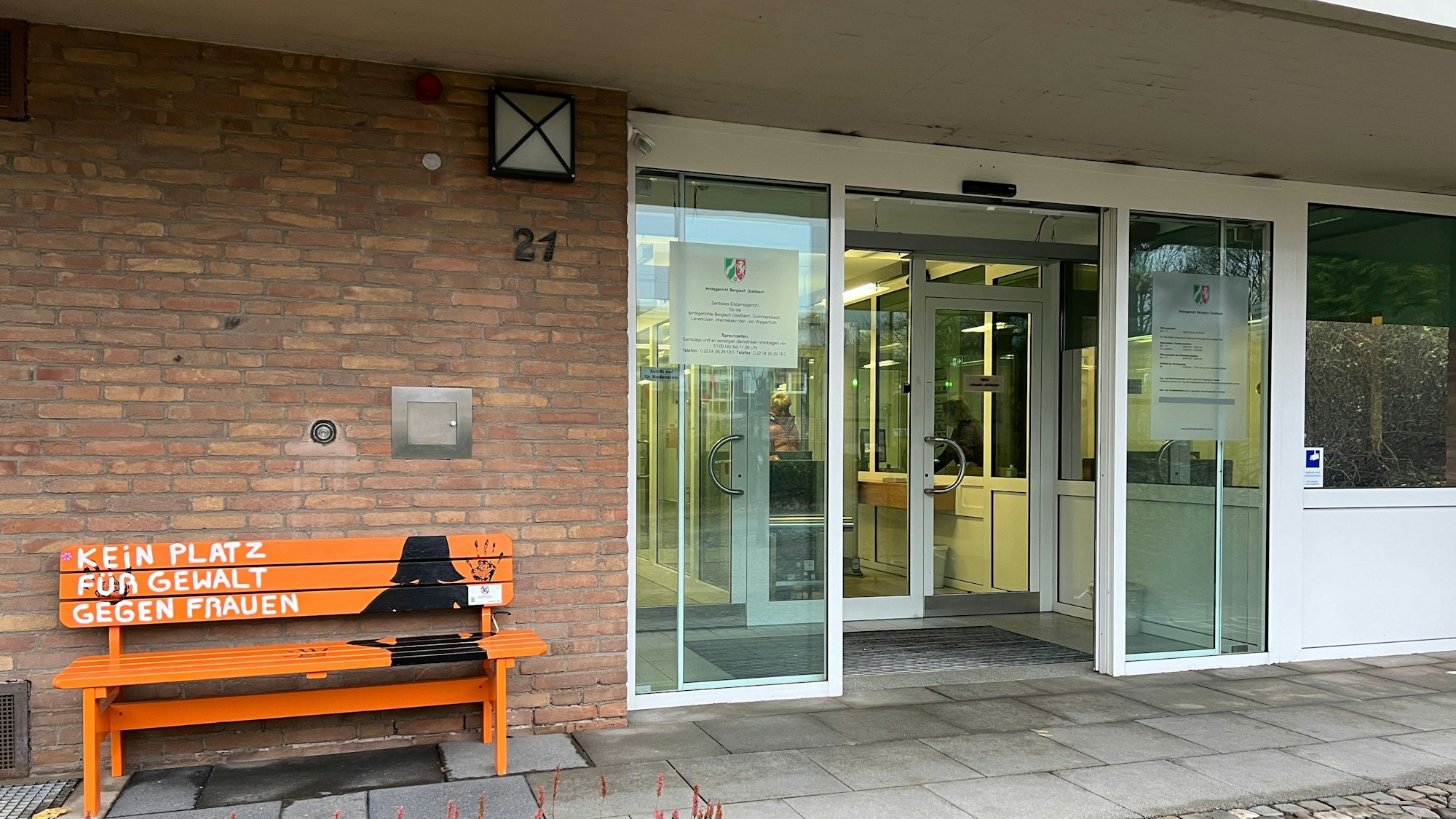 Am Eingang zum Bensberger Amtsgericht steht eine orangefarbene Bank mit der Aufschrift „Kein Platz für Gewalt gegen Frauen“.